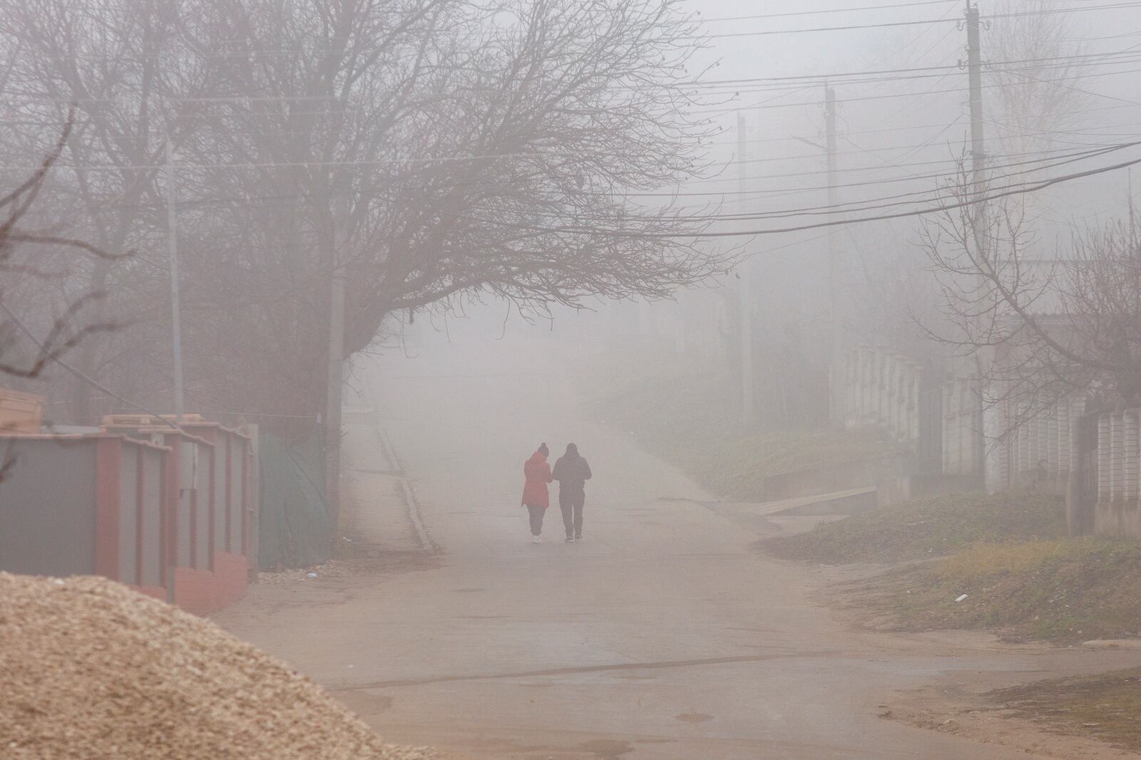 People walk on a foggy morning in the village of Todiresti, Moldova, Thursday, Jan. 30, 2025, where USAID supports projects for the rehabilitation and extension of the water suplly and fire hidrants networks. (AP Photo/Aurel Obreja)