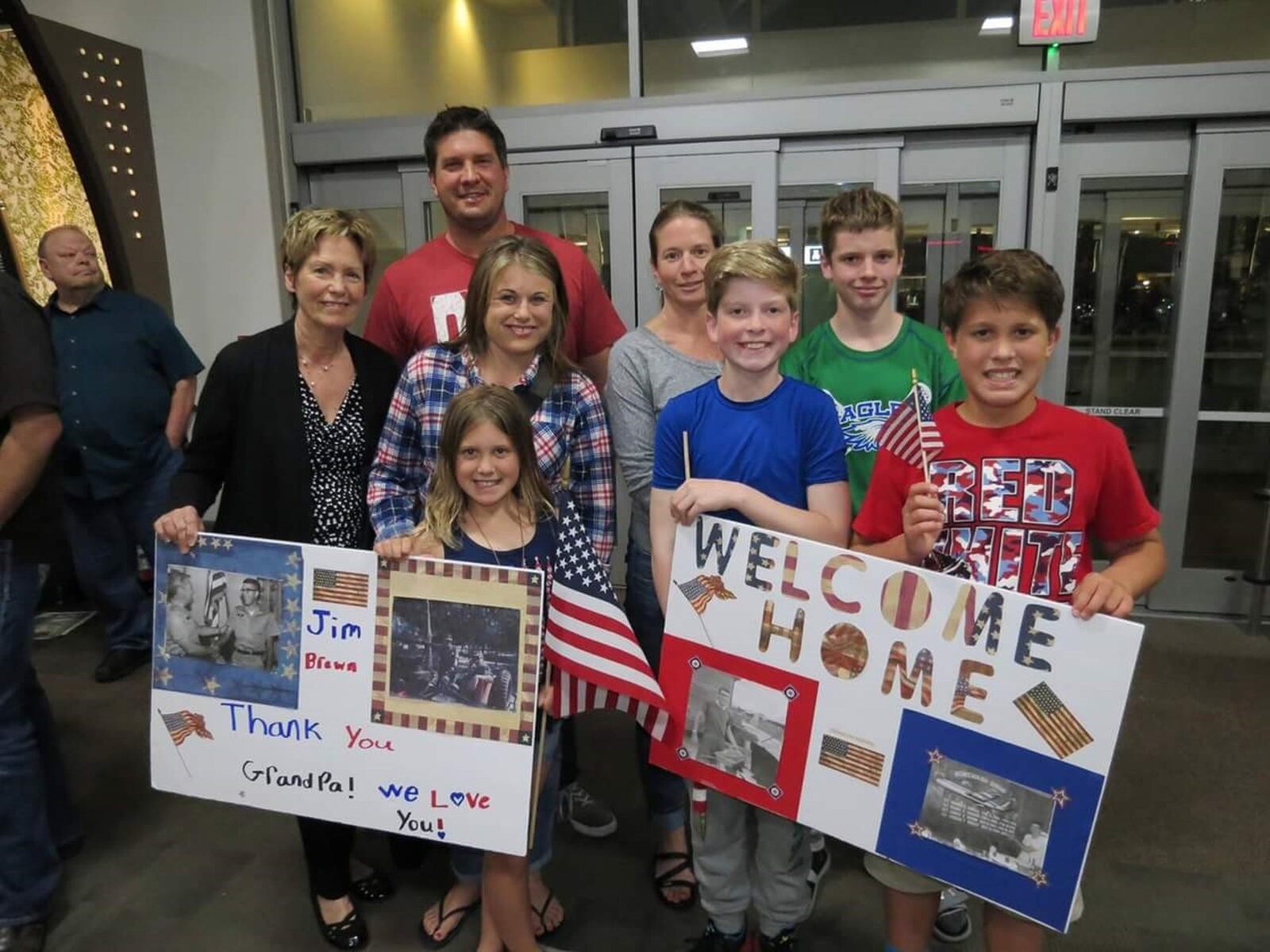 Jim Brown family at Dayton International Airport waiting to give him a hero s welcome after he got off Honor Flight to Washington DC last year. Becky, wife of 51 years, on left, son Anthony (a former WSU basketball player) in rear Jim s two daughters-in- law (Amy & Ellen) and four grandkids. CONTRIBUTED