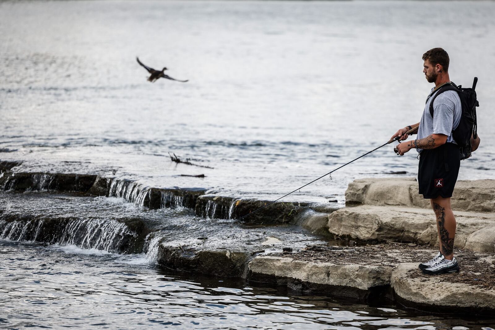 George Thomas, from Fairfield Ohio, fishes on the Great Miami River near RiverScape Metro Park Wednesday August 17, 2022. Scientist believe in 30 years Southwestern Ohio will be in the "extreme heat belt" which will effect the way we work and play. JIM NOELKER/STAFF