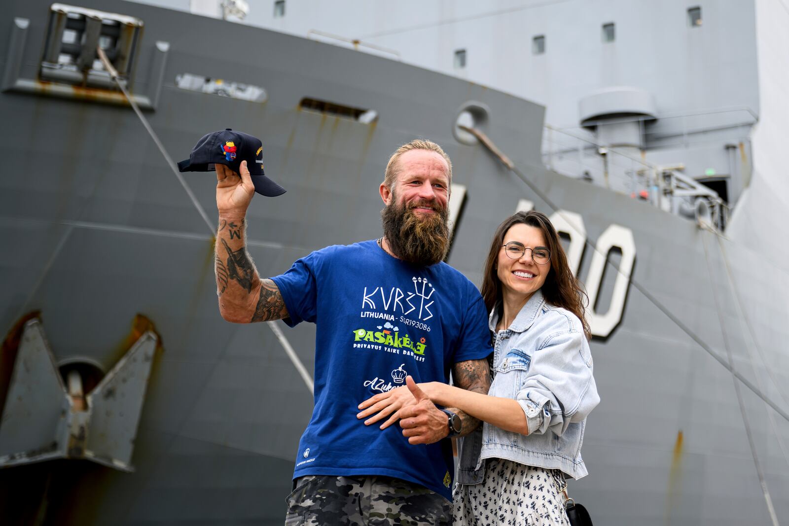 Rescued Lithuanian rower Aurimas Mockus, left, and his wife Sonata Mockuviene pose for a photograph in front of the HMAS Choules after being reunited at HMAS Kuttabul naval base in Sydney, Australia, Friday, March 7, 2025. (Bianca De Marchi/AAP Image via AP)