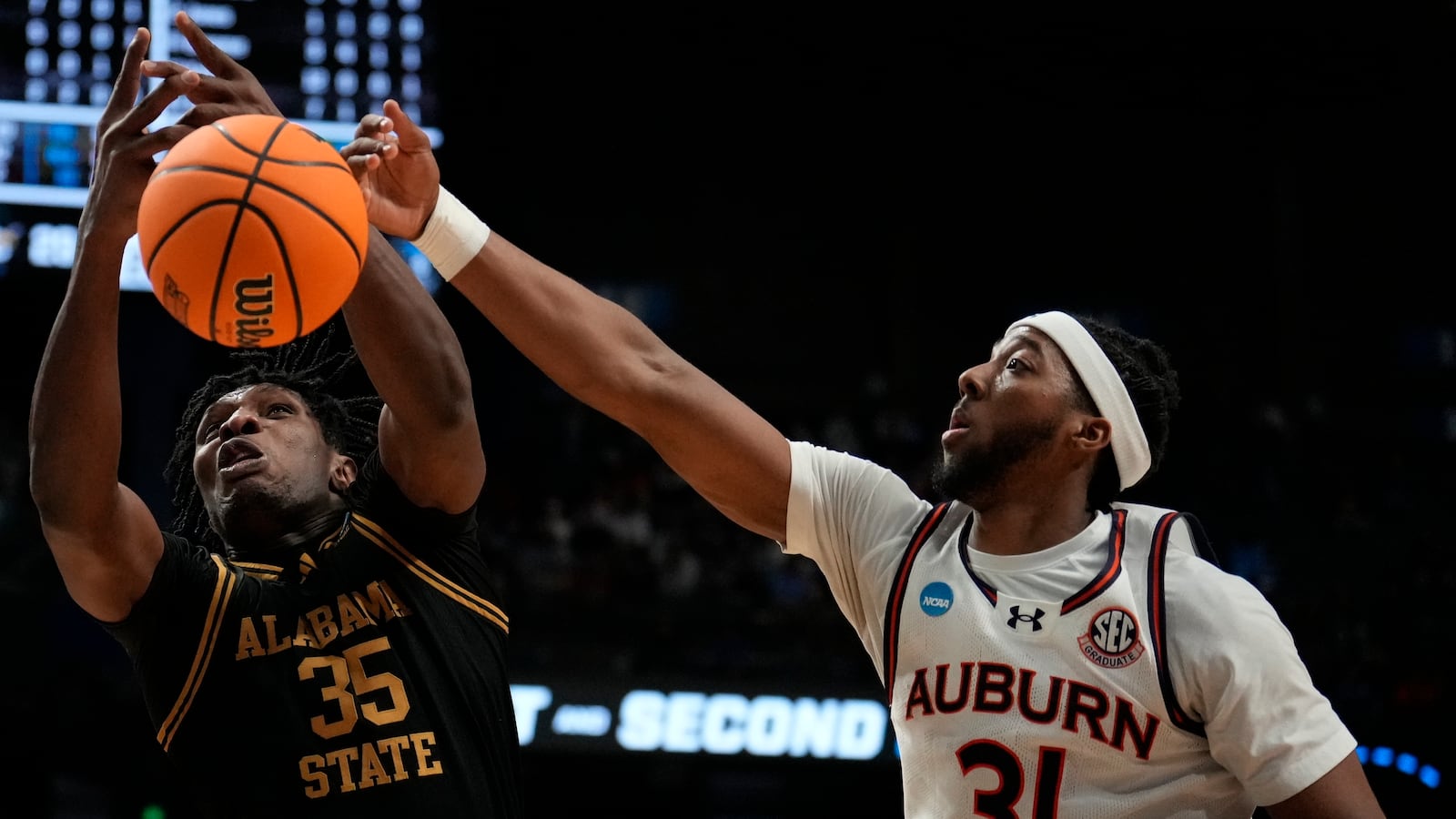 Alabama State center Ubong Okon (35) and Auburn forward Chaney Johnson (31) chase a loose ball during the first half in the first round of the NCAA college basketball tournament, Thursday, March 20, 2025, in Lexington, Ky. (AP Photo/Brynn Anderson)