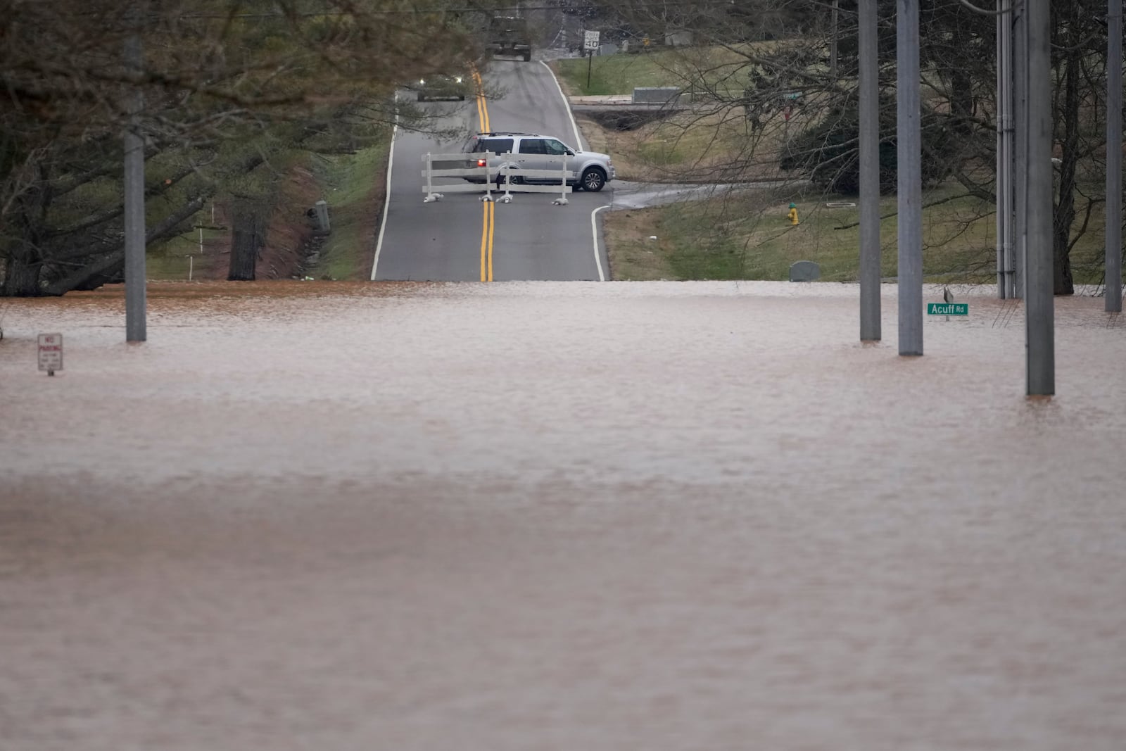 A vehicle turns around at a road closure for flooding along Dunbar Cave Rd., Sunday, Feb. 16, 2025, in Clarksville, Tenn. (AP Photo/George Walker IV)