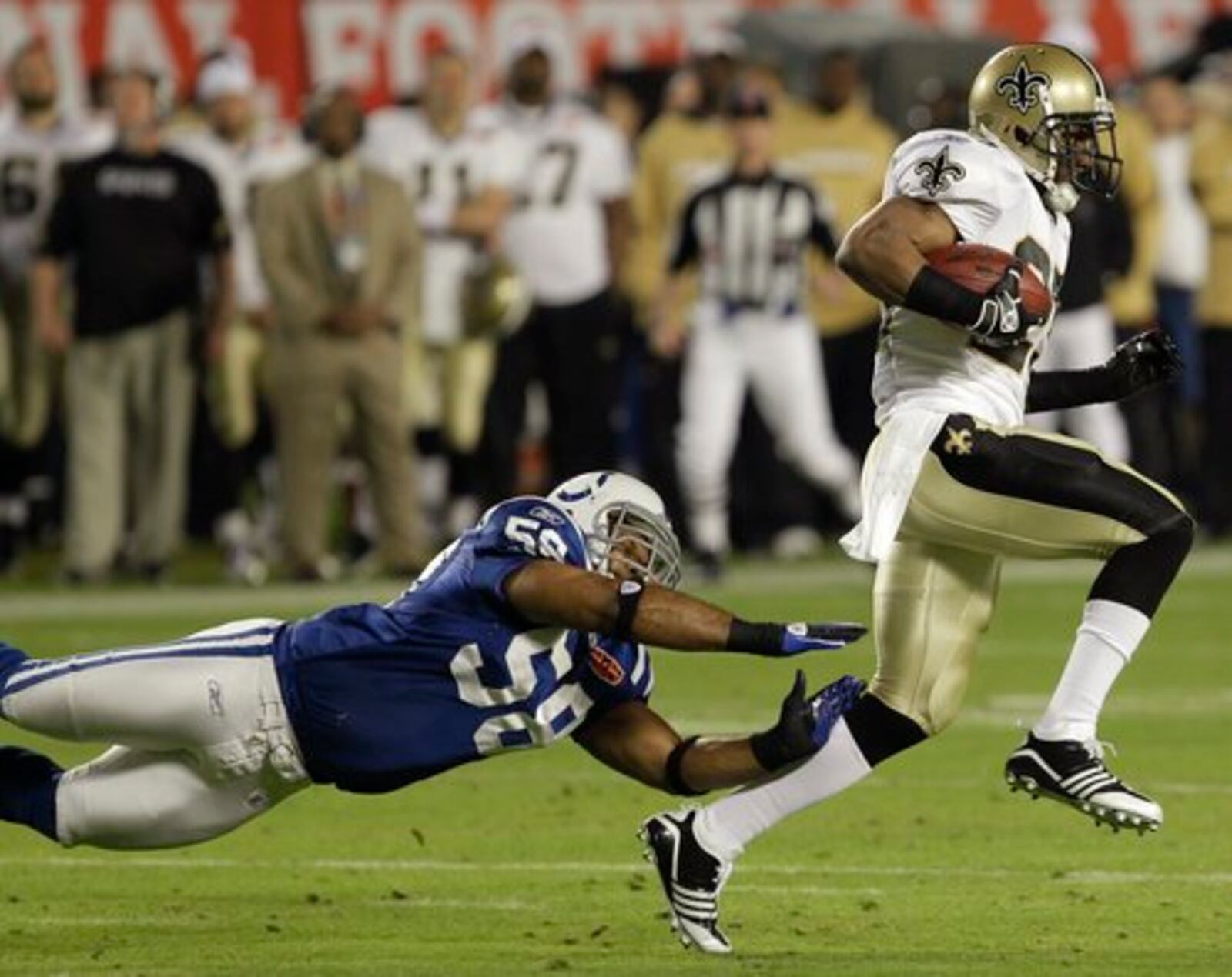 Colts linebacker Gary Brackett (58) dives after New Orleans Saints running back Reggie Bush.