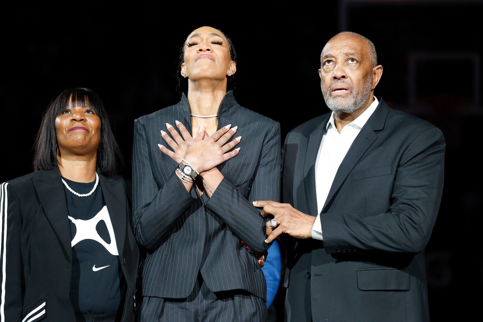 A'ja Wilson, center, stands with her parents Eva and Roscoe Wilson as they watch her number be retired during a ceremony before an NCAA college basketball game between South Carolina and Auburn in Columbia, S.C., Sunday, Feb. 2, 2025. (AP Photo/Nell Redmond)