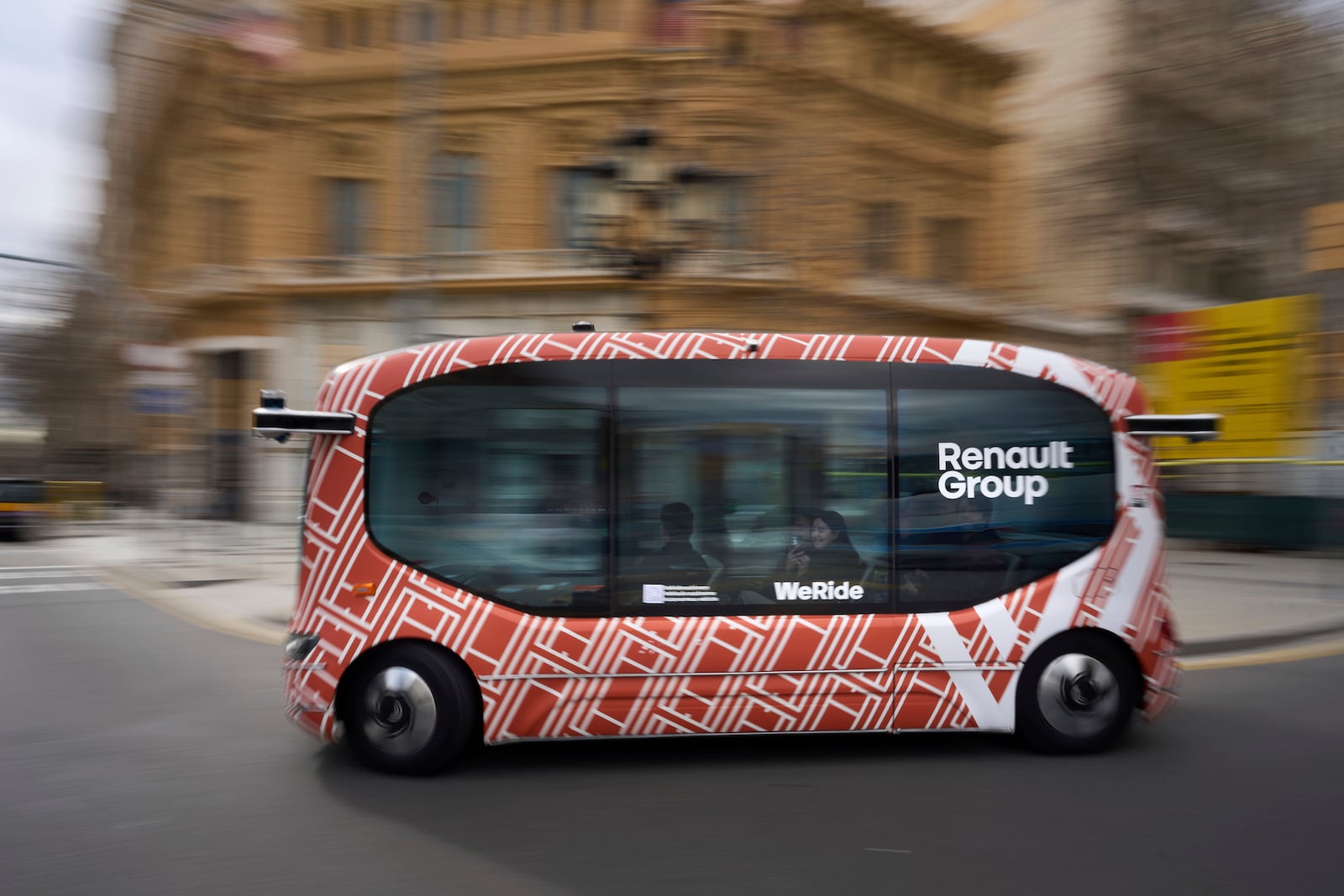 A driverless mini-bus, presented by WeRide and Renault Group, drives along a street in Barcelona downtown, Wednesday, March 12, 2025. (AP Photo/Emilio Morenatti)