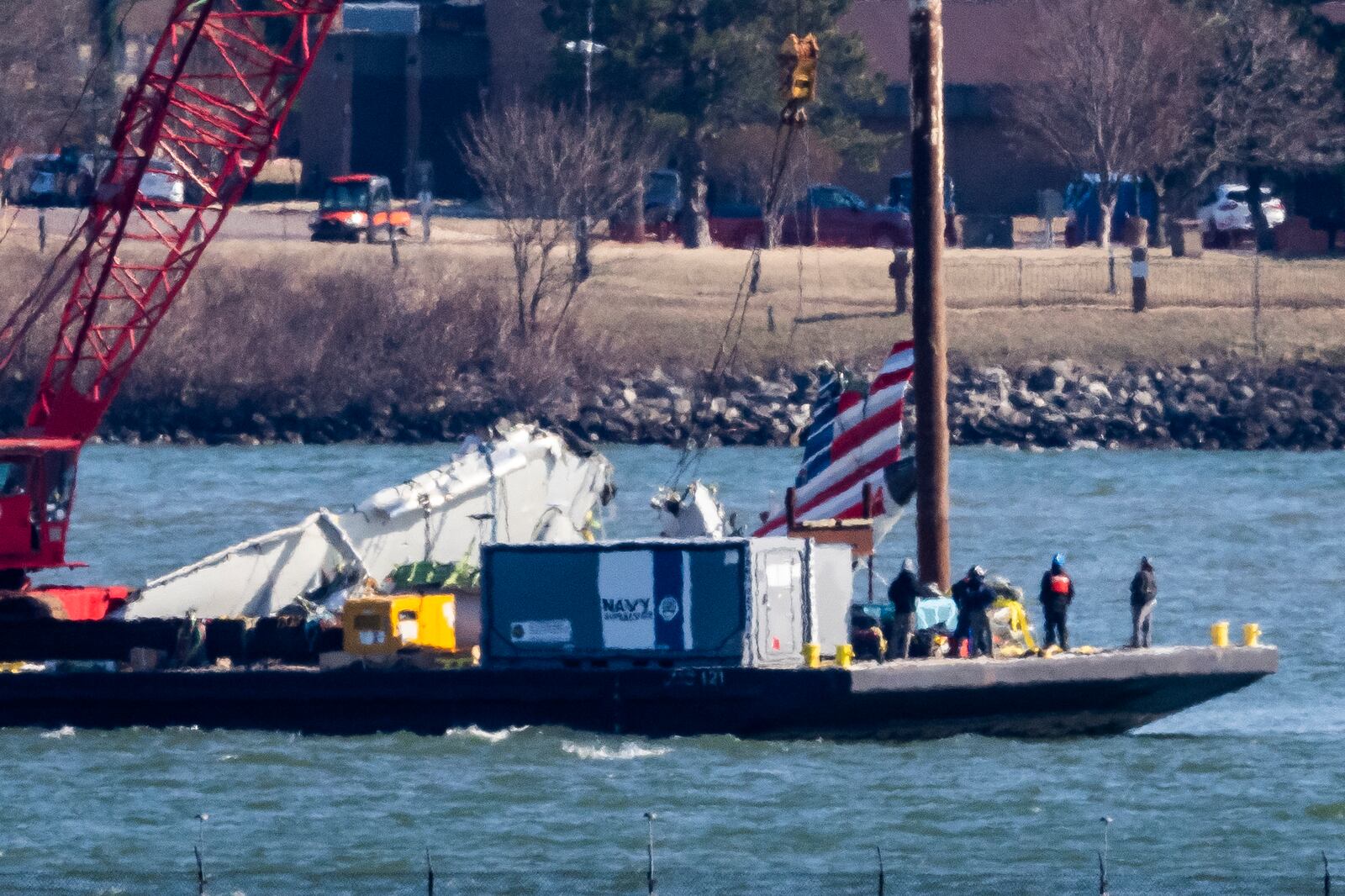 Parts of a plane are lifted from the water near the wreckage site in the Potomac River of a mid-air collision between an American Airlines jet and a Black Hawk helicopter, at Ronald Reagan Washington National Airport, Tuesday, Feb. 4, 2025, in Arlington, Va. (AP Photo/Ben Curtis)