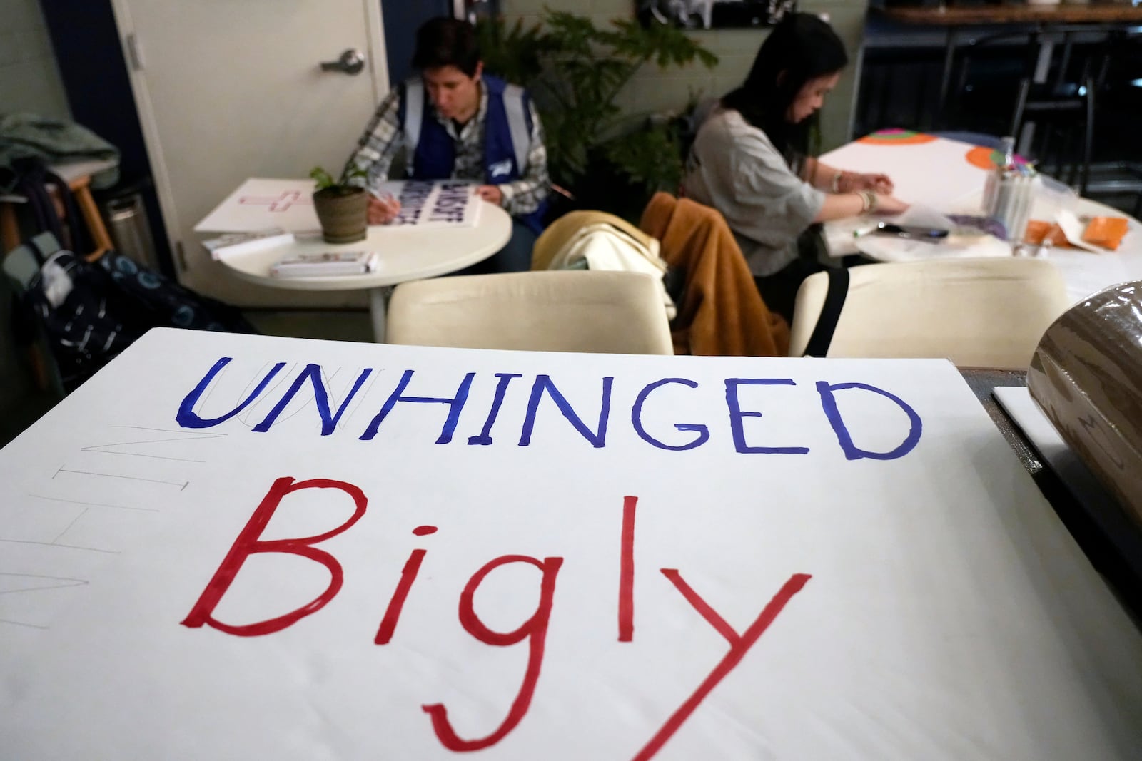 Members of NC Forward work on protest signs during a meeting in High Point, N.C., Tuesday, Jan. 14, 2025. The group is traveling to Washington to take part in the People's March on Jan. 18 ahead of the inauguration. (AP Photo/Chuck Burton)