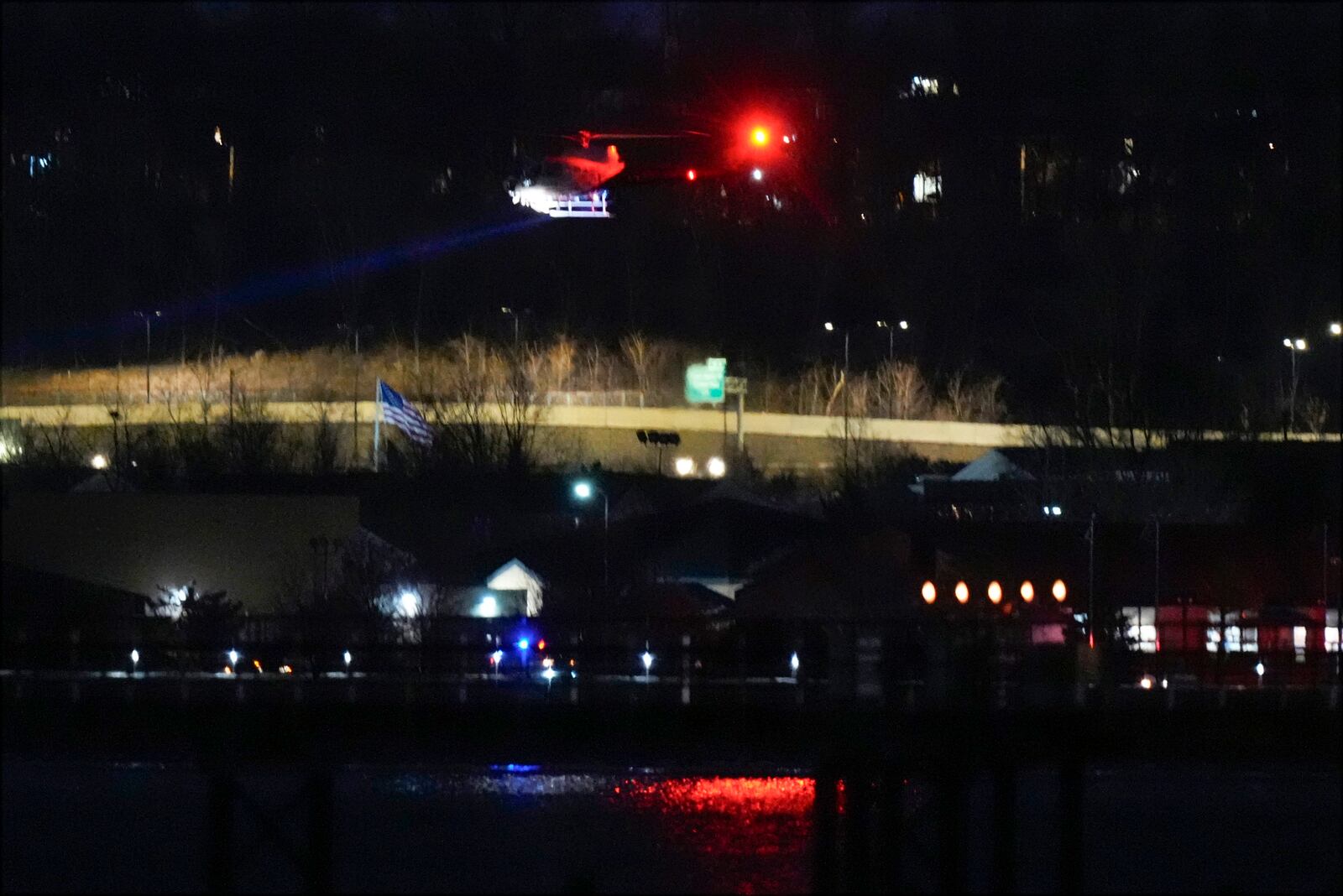 A helicopter uses its searchlight as it flies above the Potomac River near Ronald Reagan Washington National Airport Wednesday, Jan. 29, 2025, in Arlington, Va. (AP Photo/Alex Brandon)