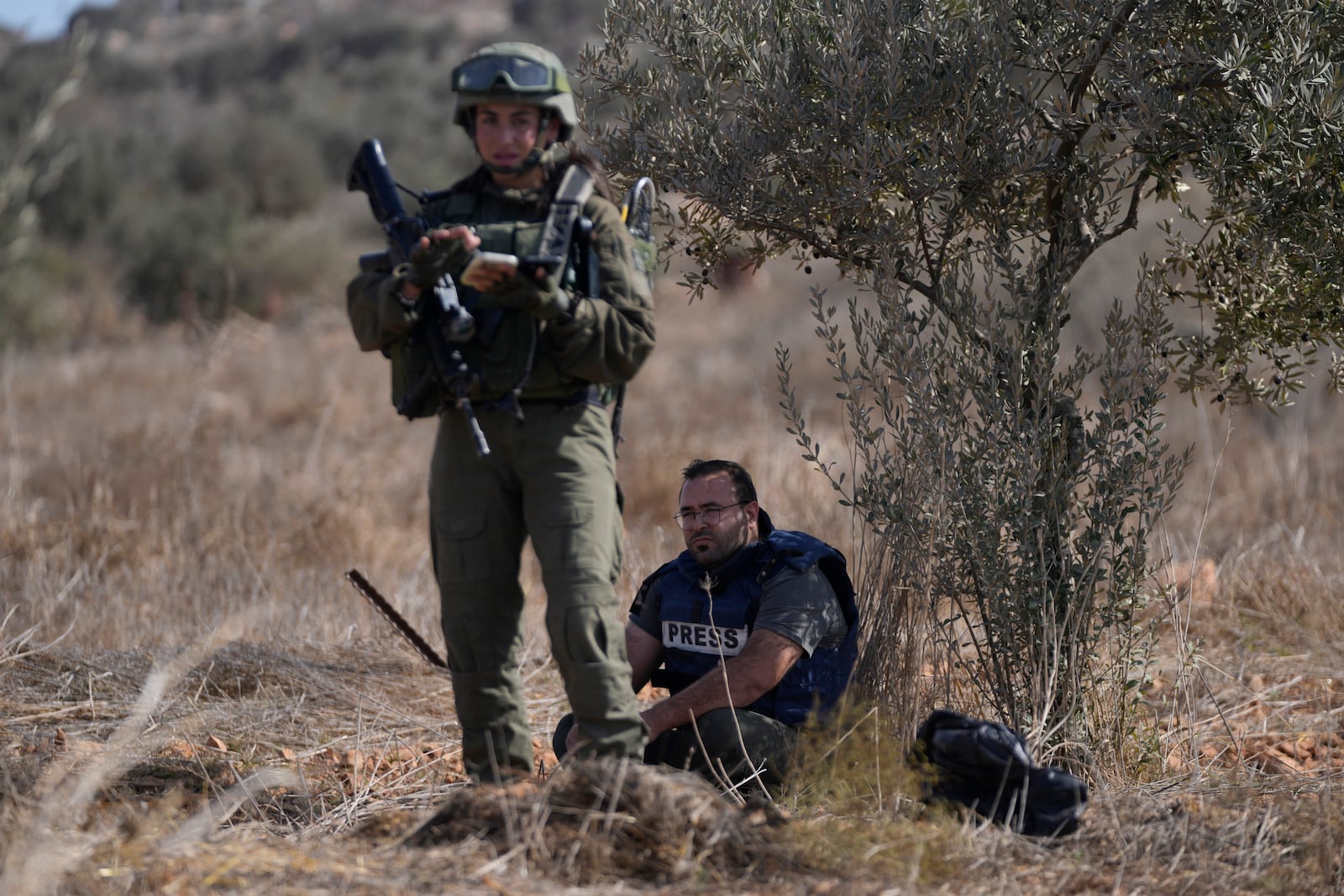 Israeli army troops temporarly detain Palestinian journalist Hesham Abu Shaqra, who was later released, while foreign activists and three European politicians joined the villagers on occasion of the Palestinian olive harvest season, and denied farmers access to their land in the West Bank town of Qusra, south of Nablus Tuesday, Oct. 29, 2024. (AP Photo/Nasser Nasser)