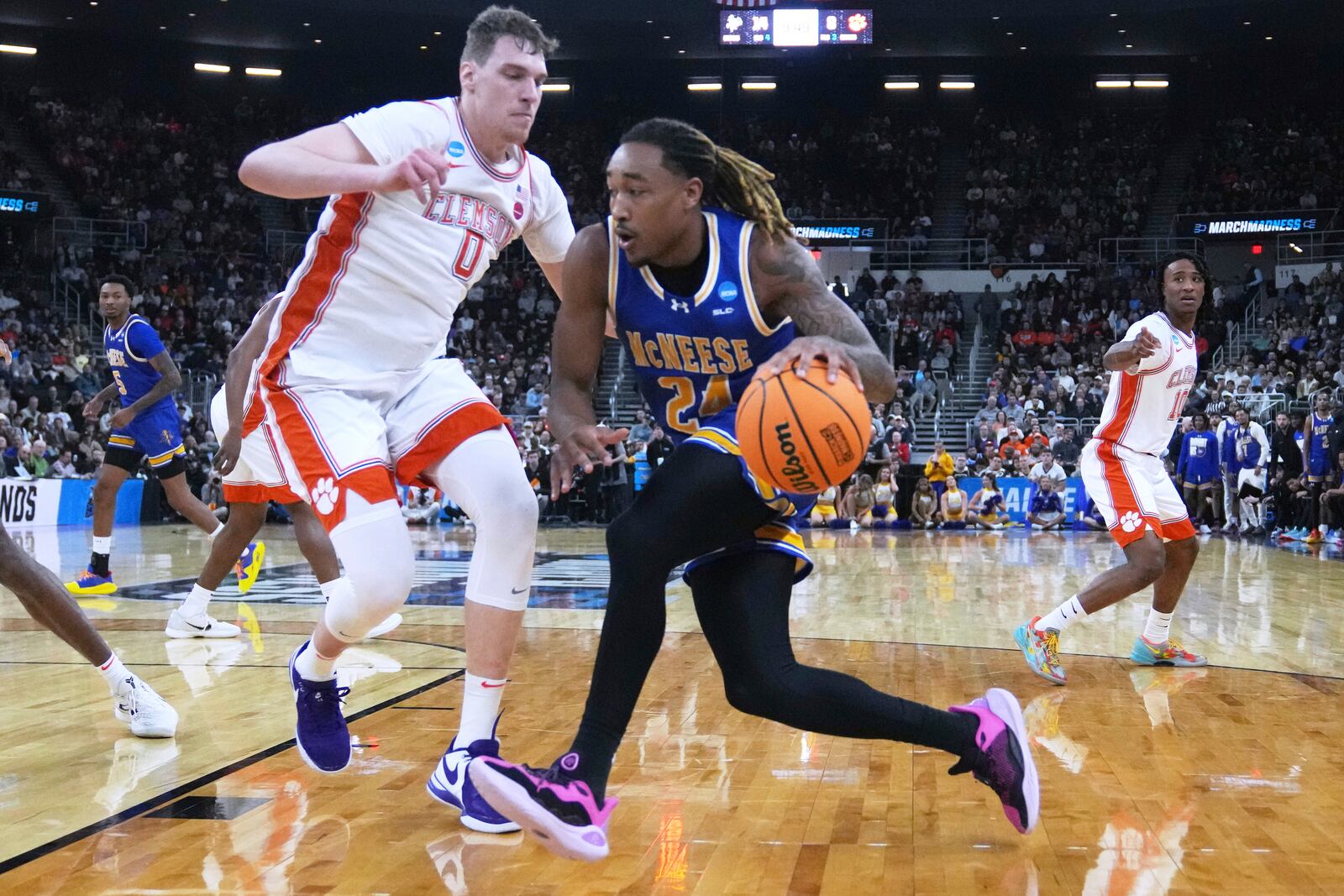 McNeese State forward Christian Shumate (24) drives to the basket past Clemson center Viktor Lakhin (0) during the first half in the first round of the NCAA college basketball tournament, Thursday, March 20, 2025, in Providence, R.I. (AP Photo/Charles Krupa)