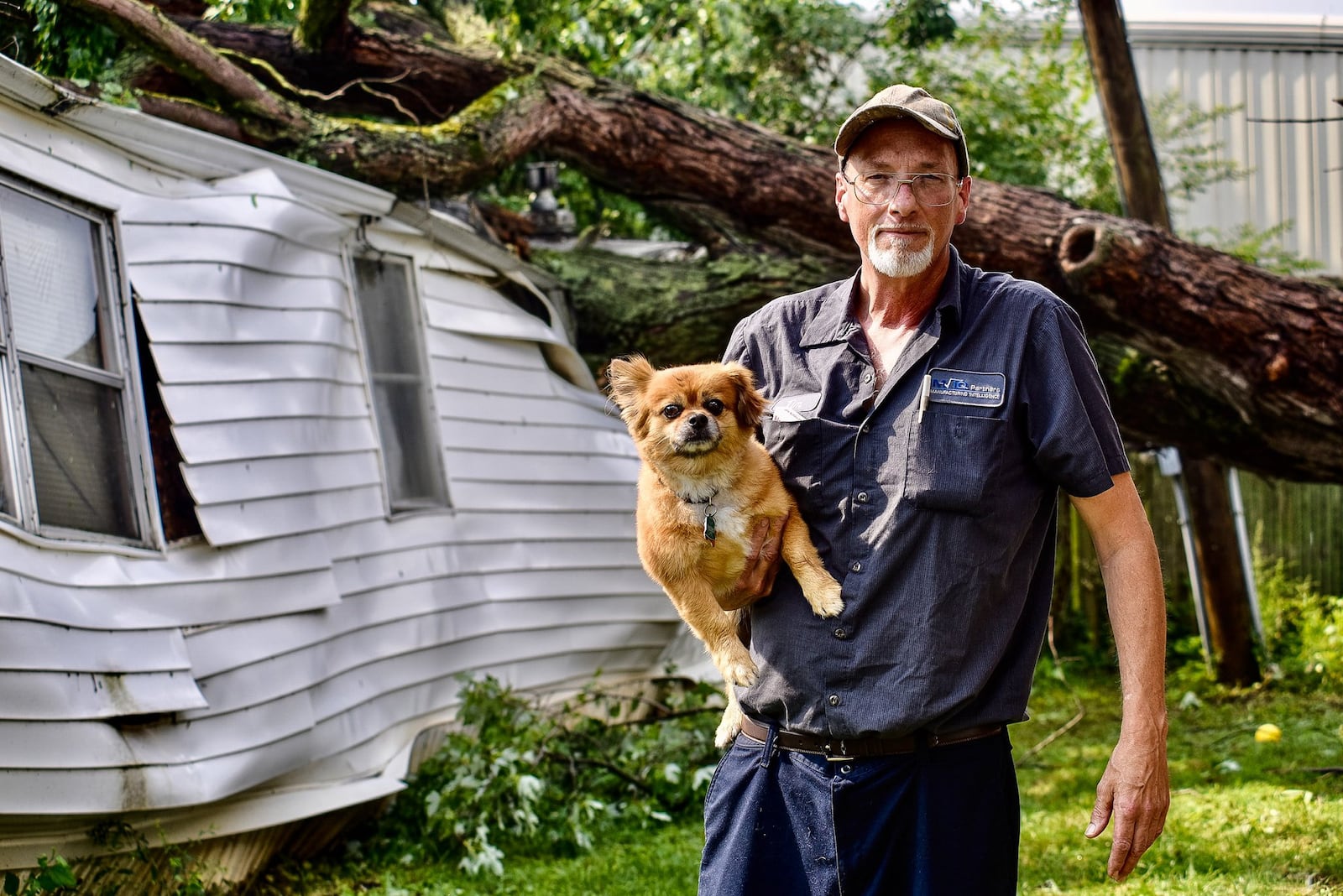 Tim Stitzel and his dog, Thor, escaped without injury when when strong winds caused a tree to fall on his trailer Thursday, July 9, 2020 at Camargo mobile home park in Liberty Township. NICK GRAHAM / STAFF