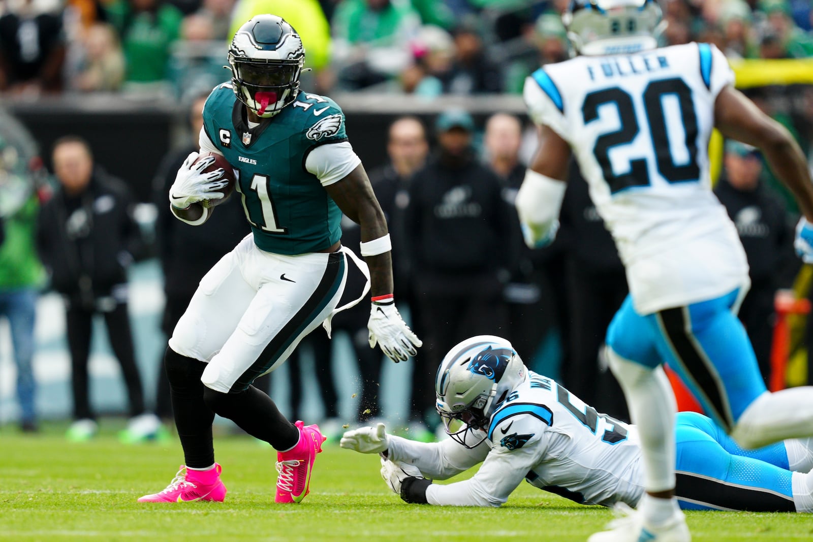 Philadelphia Eagles wide receiver A.J. Brown (11) runs the ball under pressure from Carolina Panthers linebacker Trevin Wallace (56) and Carolina Panthers safety Jordan Fuller (20) during the first half of an NFL football game Sunday, Dec. 8, 2024, in Philadelphia. (AP Photo/Derik Hamilton)