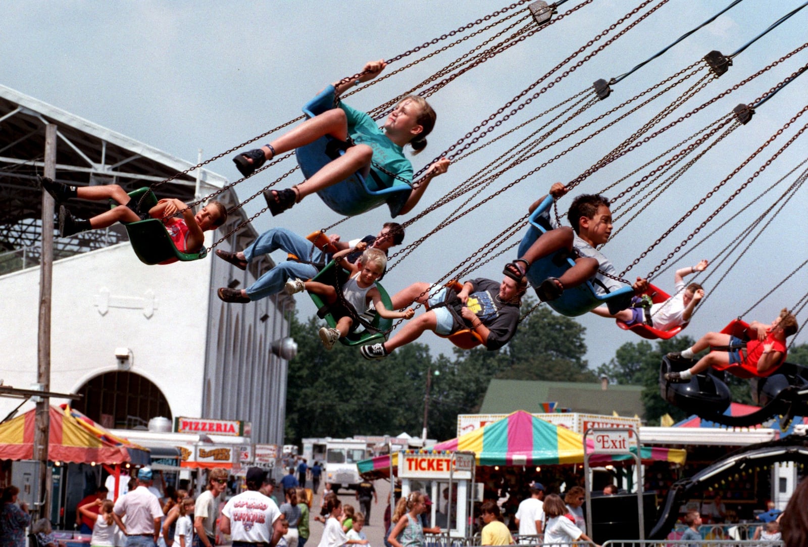 Aug. 18, 1998: The Miami County Fair in 'full swing'. Here kids ride the swings near the grandstand with the food and games section of the midway behind them.