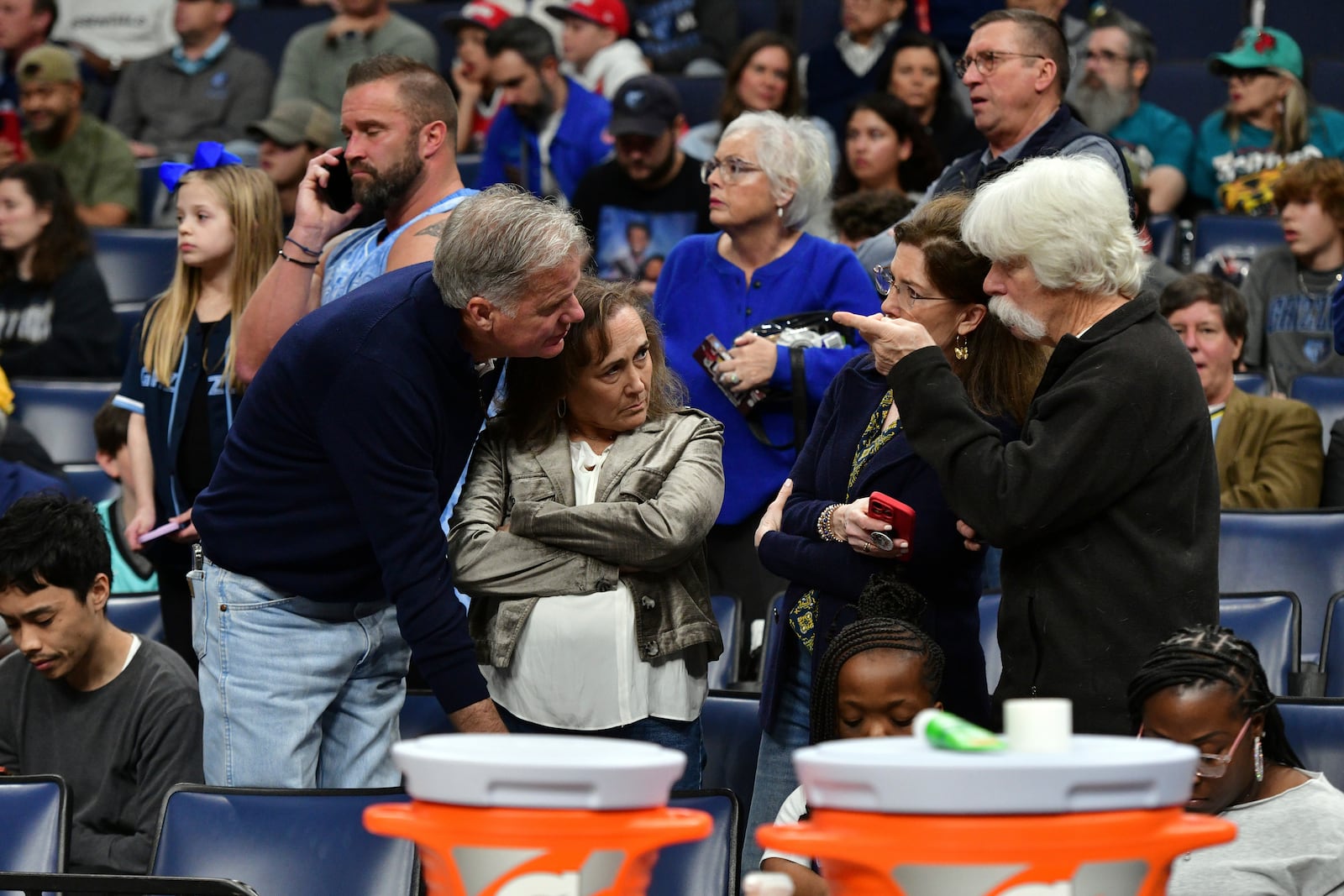 Fans react after a man suffered a medical emergency courtside just before the start of an NBA basketball game between the San Antonio Spurs and the Memphis Grizzlies, Monday, Feb. 3, 2025, in Memphis, Tenn. (AP Photo/Brandon Dill)