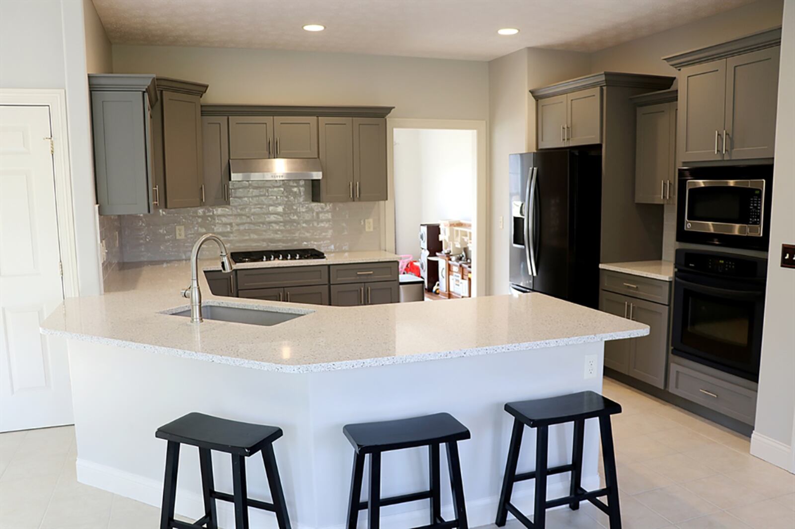 A peninsula counter wraps around the kitchen, creating a step-saving work space and breakfast bar seating for up to six. A stainless-steel sink is nestled within the countertop. CONTRIBUTED PHOTO BY KATHY TYLER