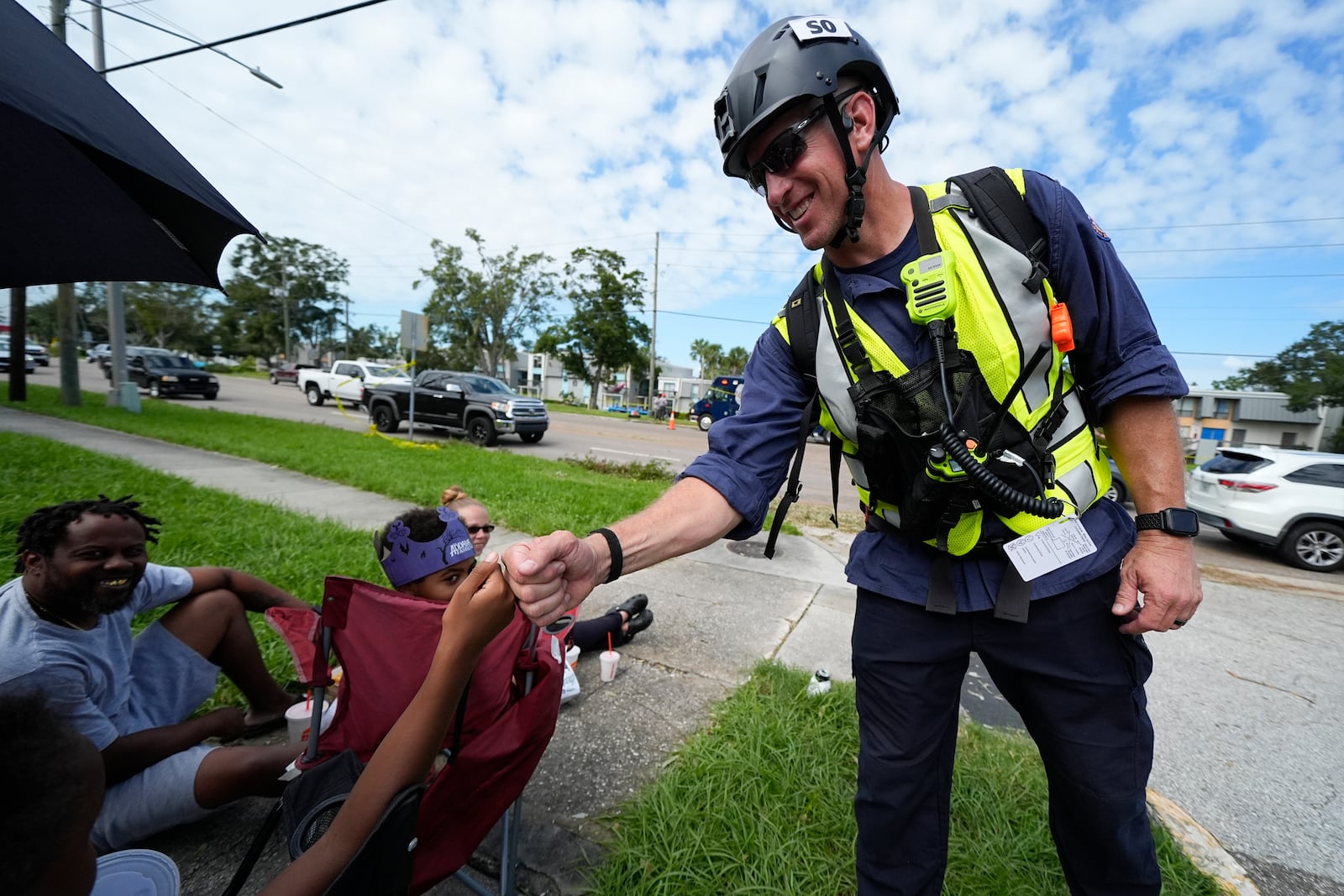 A FEMA official gives a fist bump to Alycia Scott, 9, after he inspected the apartment complex where Scott's resides and was flooded during Hurricane Milton, Friday, Oct. 11, 2024, in Clearwater, Fla. (AP Photo/Julio Cortez)