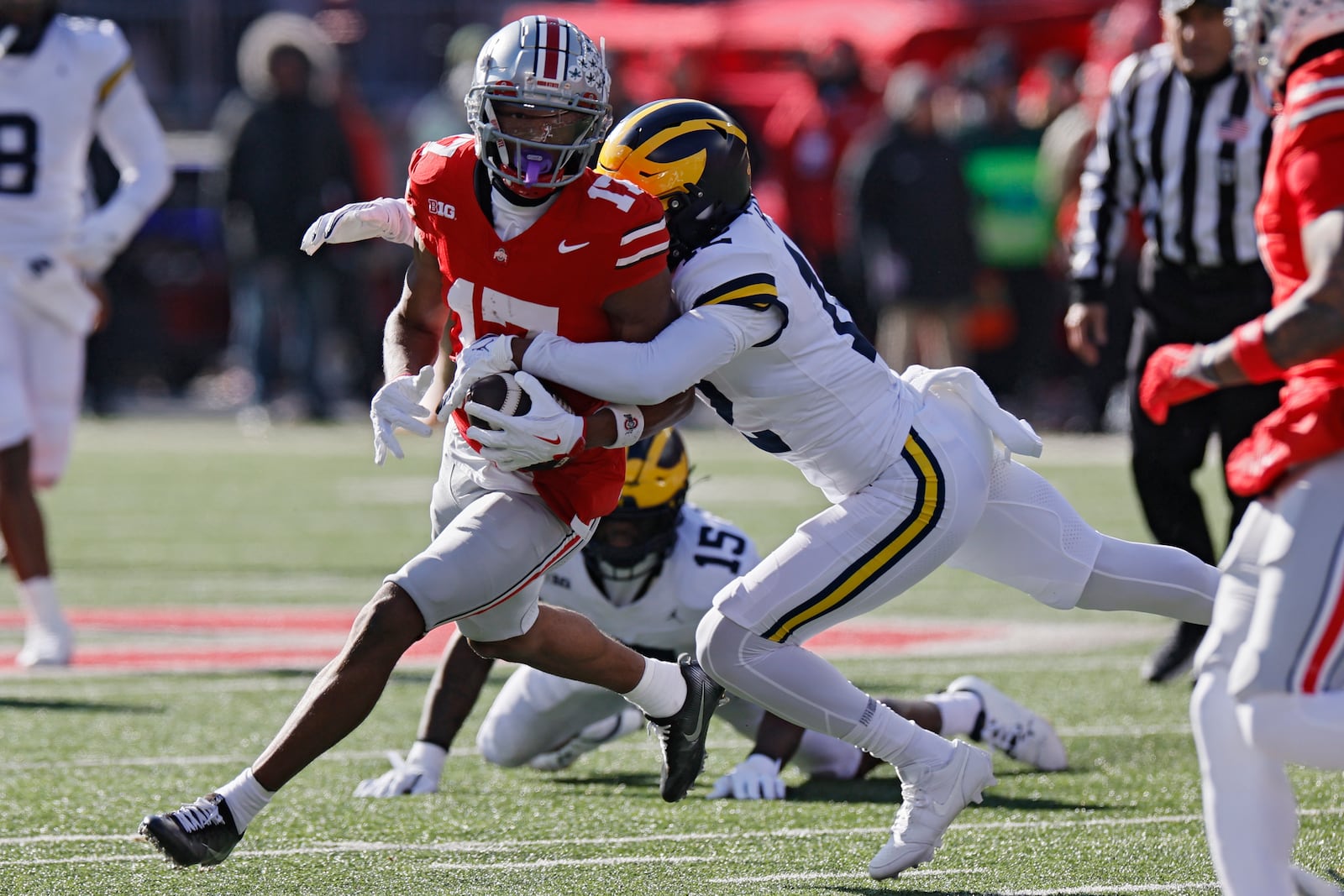 Ohio State receiver Carnell Tate, left, is tackled by Michigan defensive back Aamir Hall during the first half of an NCAA college football game Saturday, Nov. 30, 2024, in Columbus, Ohio. (AP Photo/Jay LaPrete)