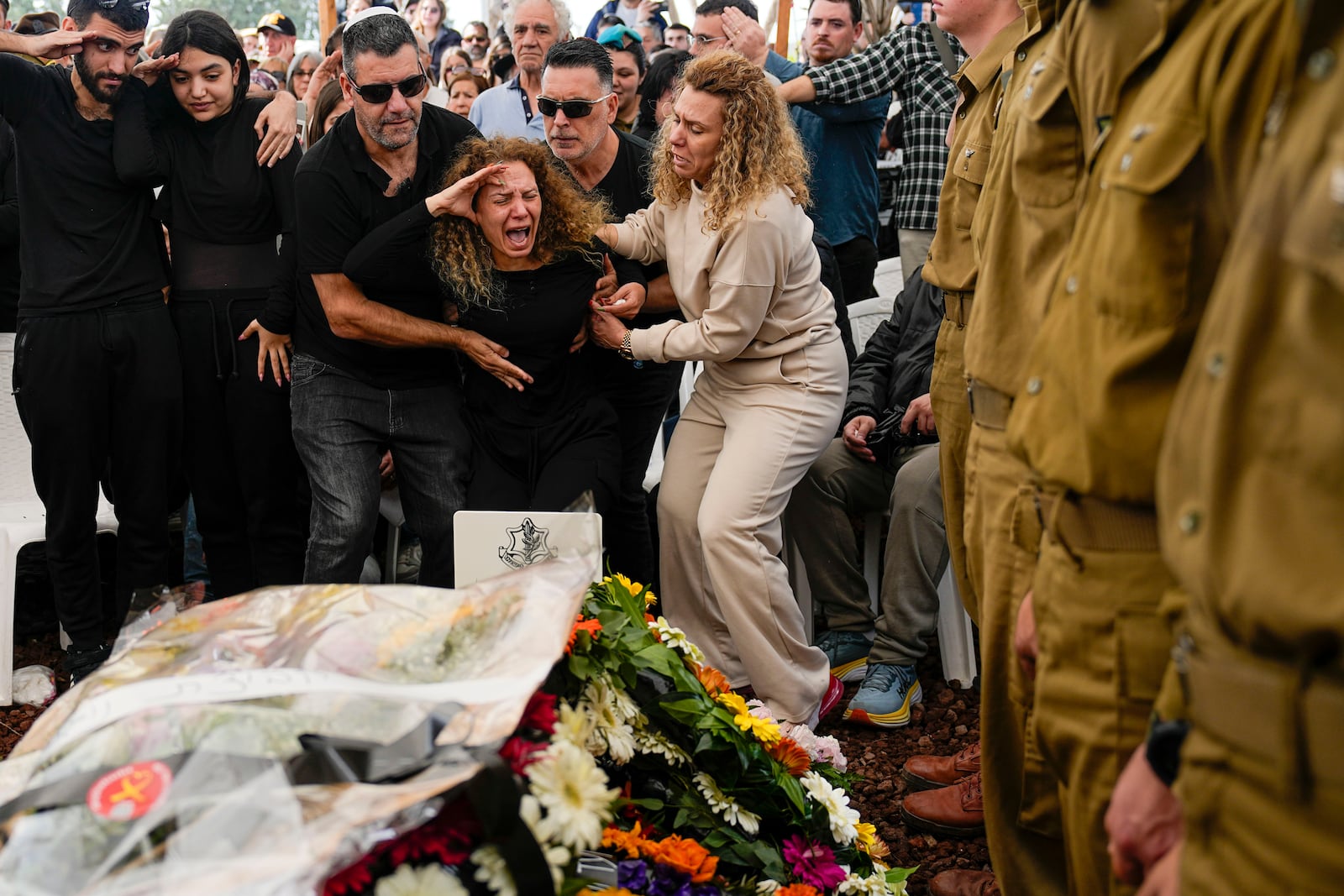 Sivan, mother of Israeli soldier, Sergeant Dolev Malca, was killed during Israel's ground operation in the Gaza Strip, screams as she salutes her son during his funeral in Shlomi, northern Israel, on the border with Lebanon, Sunday, March 3, 2024. (AP Photo/Ariel Schalit)