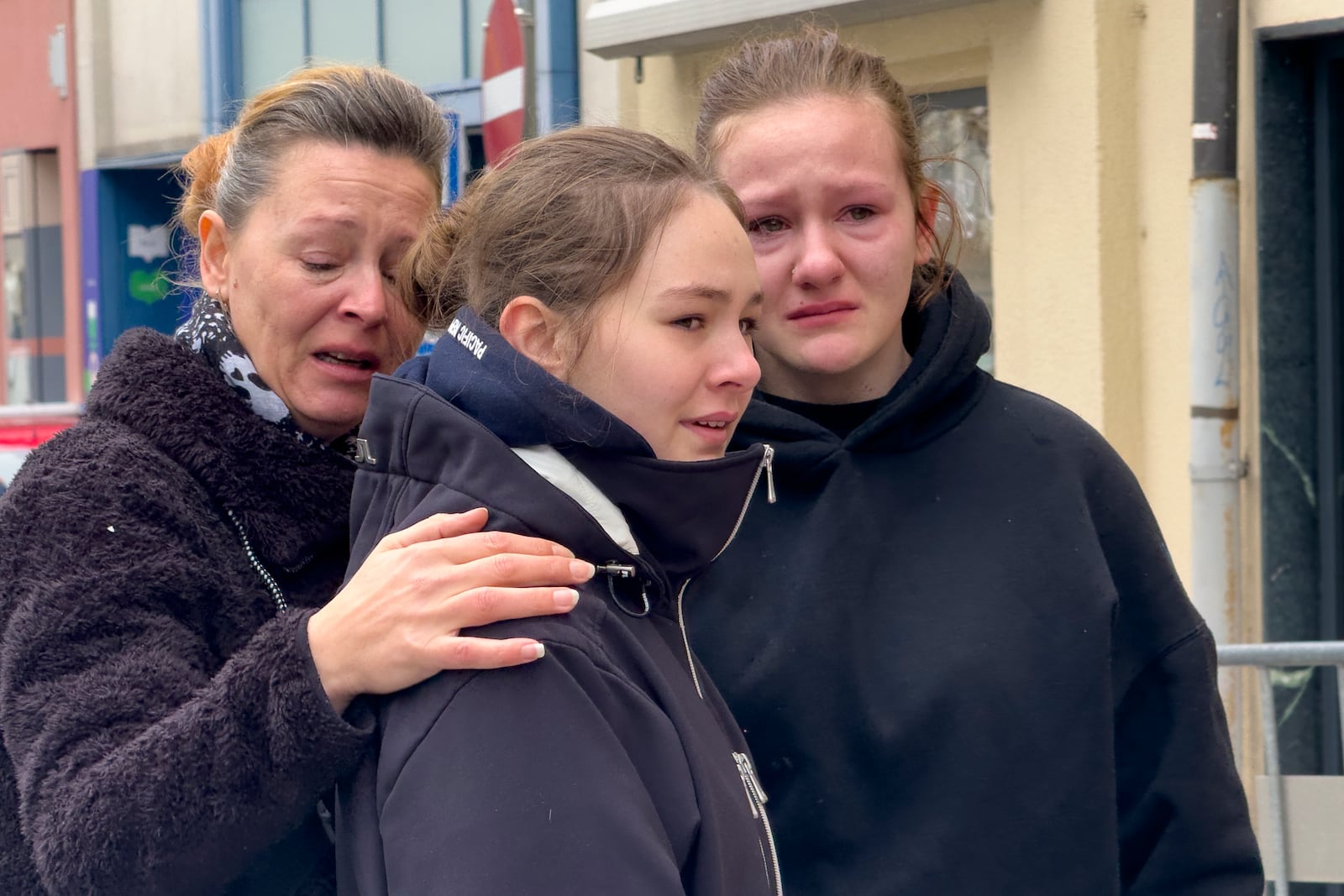 People mourn at the site of stabbing a day after an attack that left a 14-year-old dead and five others injured, in Villach, Austria, Sunday, Feb. 16, 2025. (AP Photo/Darko Bandic)