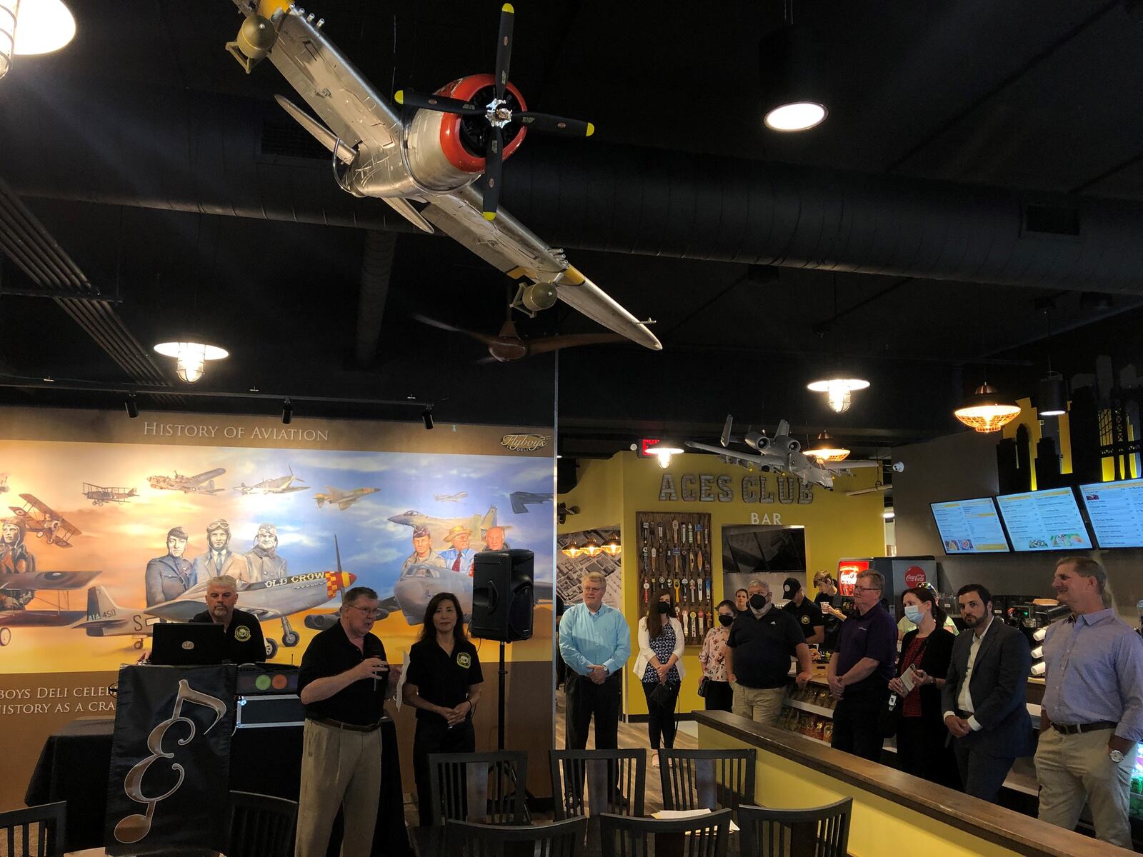 Steve Crandall and Eunice Kim address a crowd gathered for the grand opening of the Flyboy's Deli at 219 N. Patterson Blvd. in downtown Dayton last month. The space on the ground floor of a parking garage across from Day Air Ballpark had been vacant for more than a decade. CORNELIUS FROLIK / STAFF