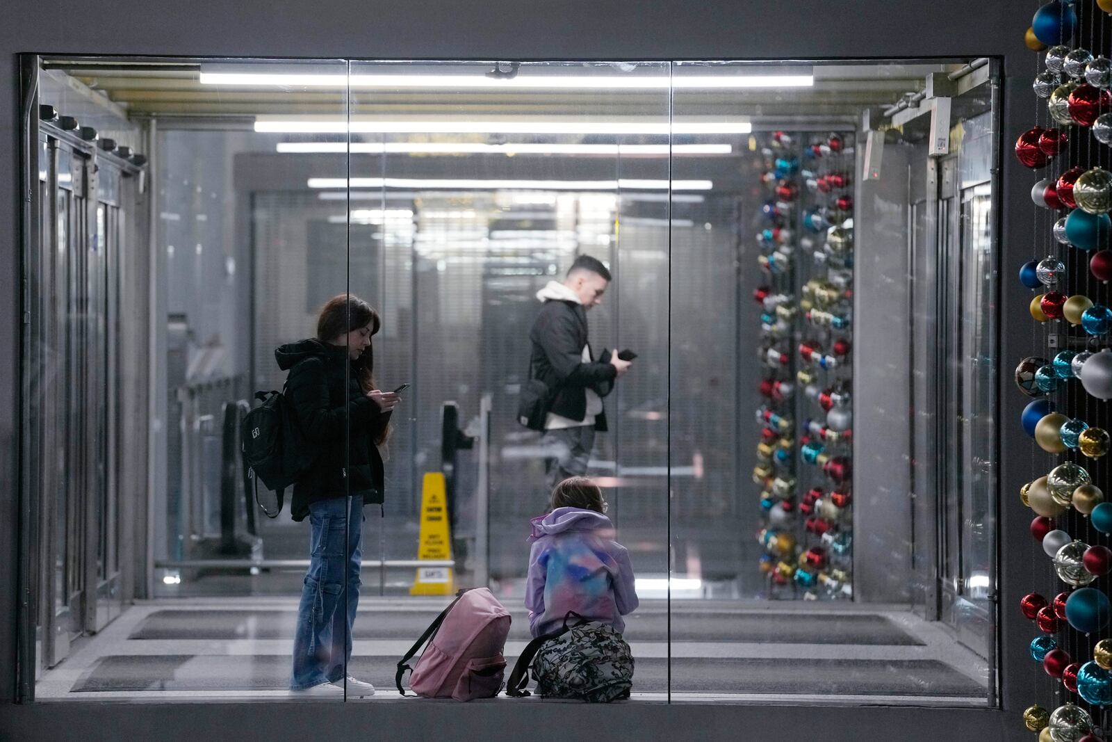 Travelers wait for their ride at O'Hare International Airport in Chicago, Tuesday, Nov. 26, 2024. (AP Photo/Nam Y. Huh)