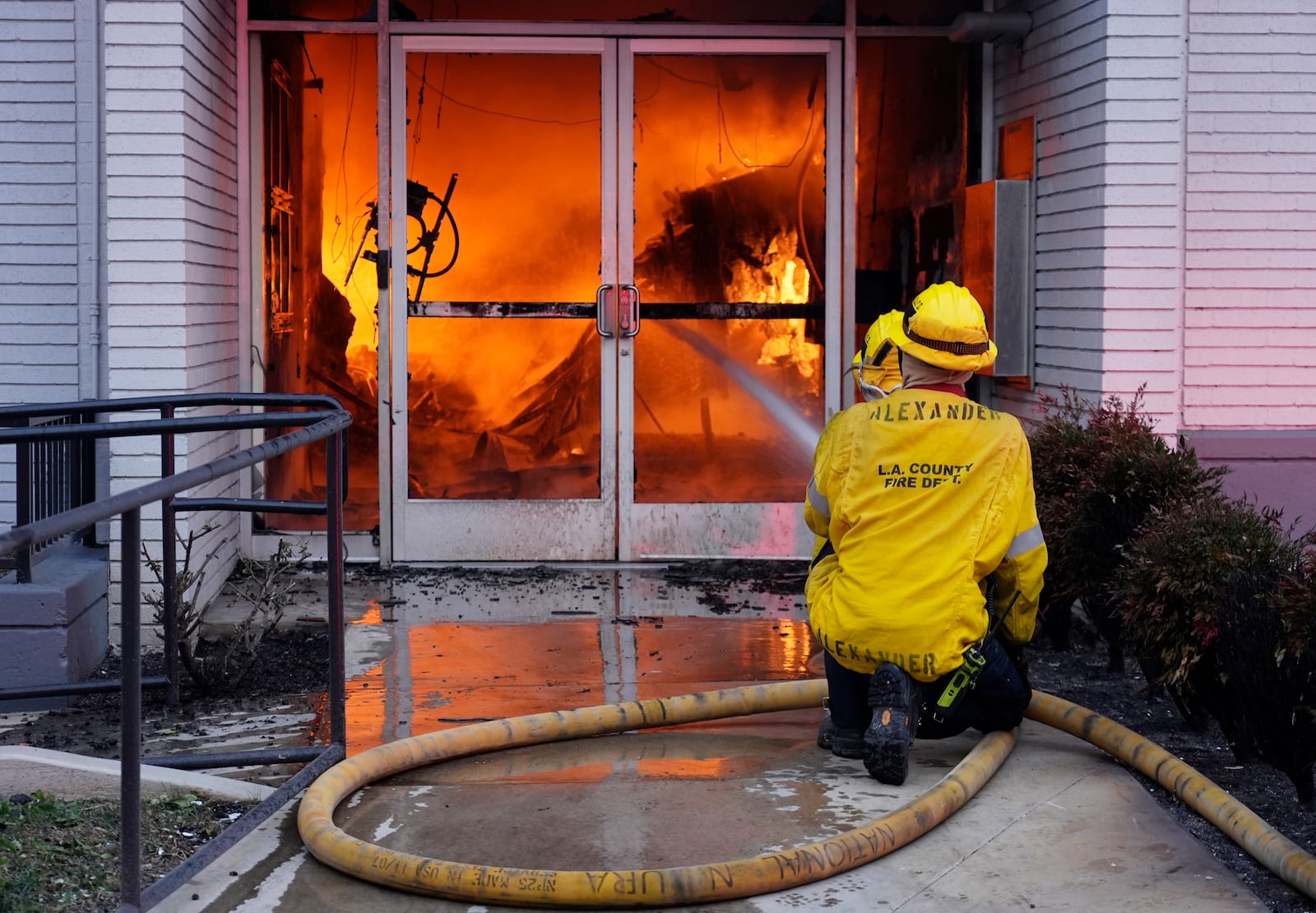 Firefighters aim a hose at the entrance to a Bank of America engulfed in flames on Lake Avenue, Wednesday, Jan. 8, 2025, in the Altadena section of Pasadena, Calif. (AP Photo/Chris Pizzello)