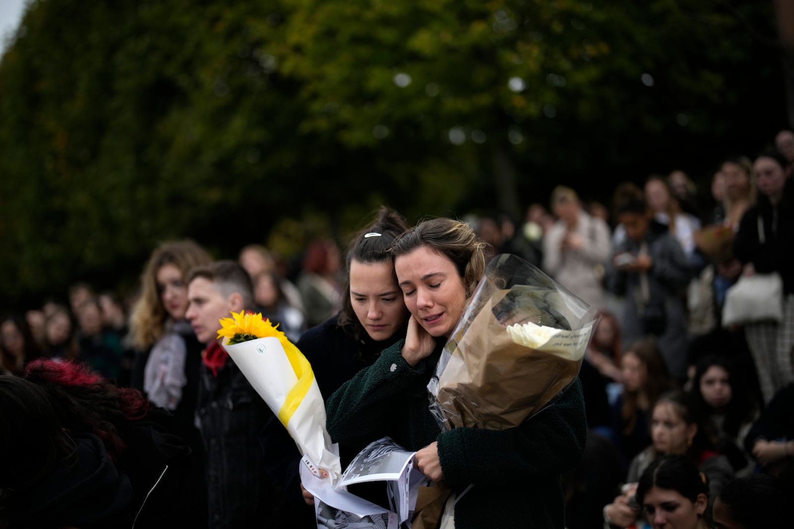 Fans gather to pay tribute to late British singer Liam Payne, former member of the British pop band One Direction, in Paris, France, Sunday, Oct. 20, 2024. (AP Photo/Christophe Ena)