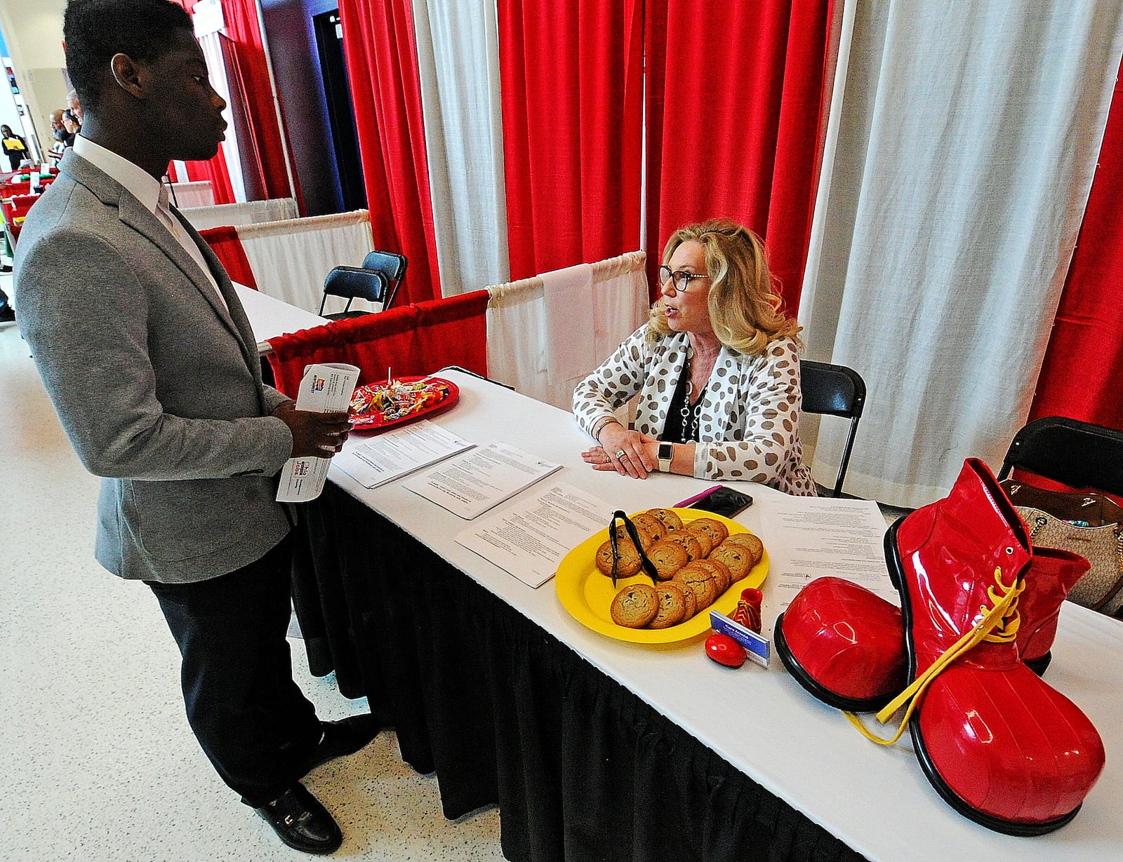 Deborah Neely from Ronald McDonald House Charities talks with Victor Kallon at the Montgomery County Workforce Development Services Spring Job Fair on Thursday, April 27, 2023 at the University of Dayton Arena. MARSHALL GORBY\STAFF