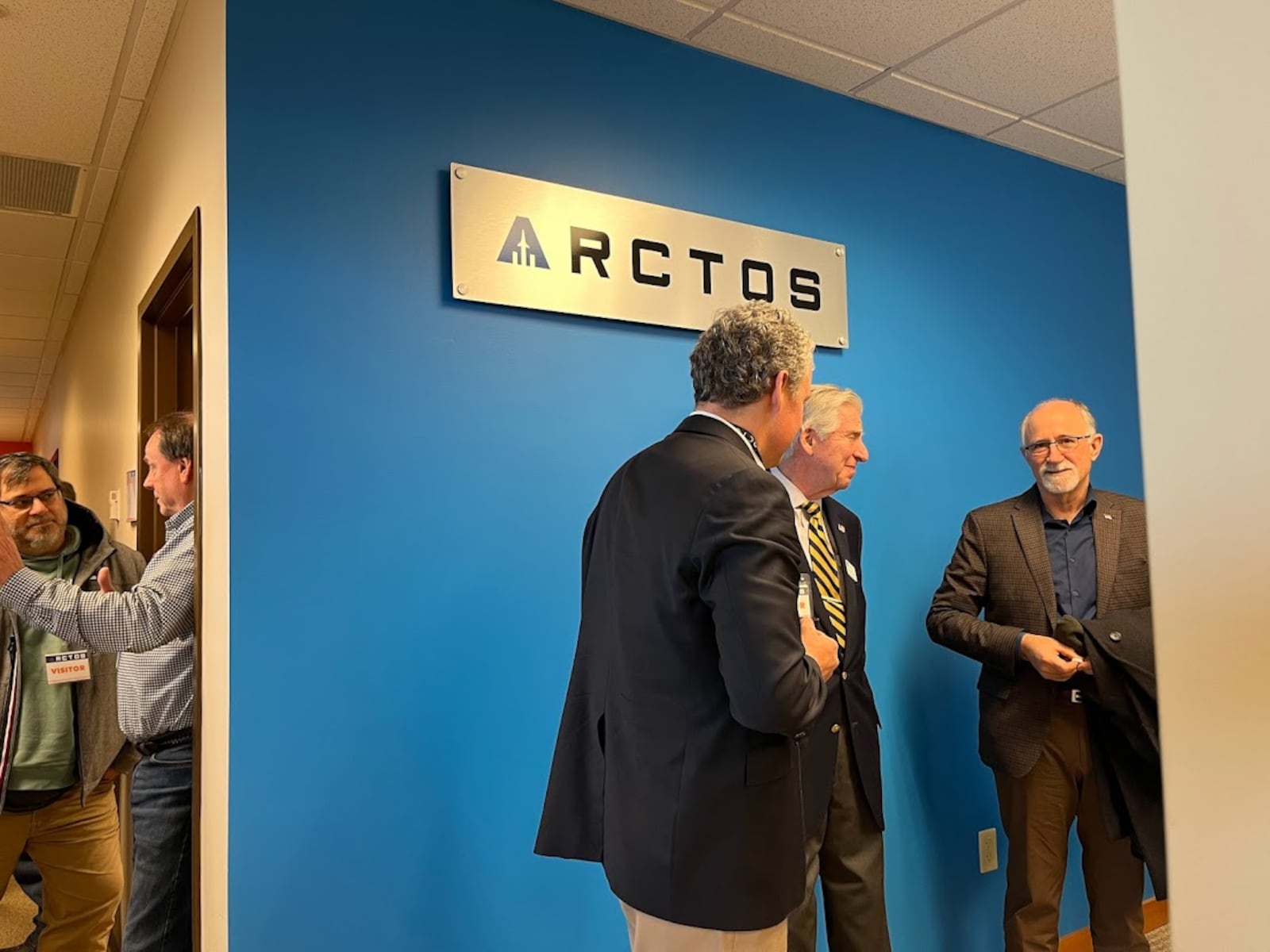 Joe Sciabica, on the right, chats with friends at the ARCTOS ribbon cutting gathering Tuesday. THOMAS GNAU/STAFF