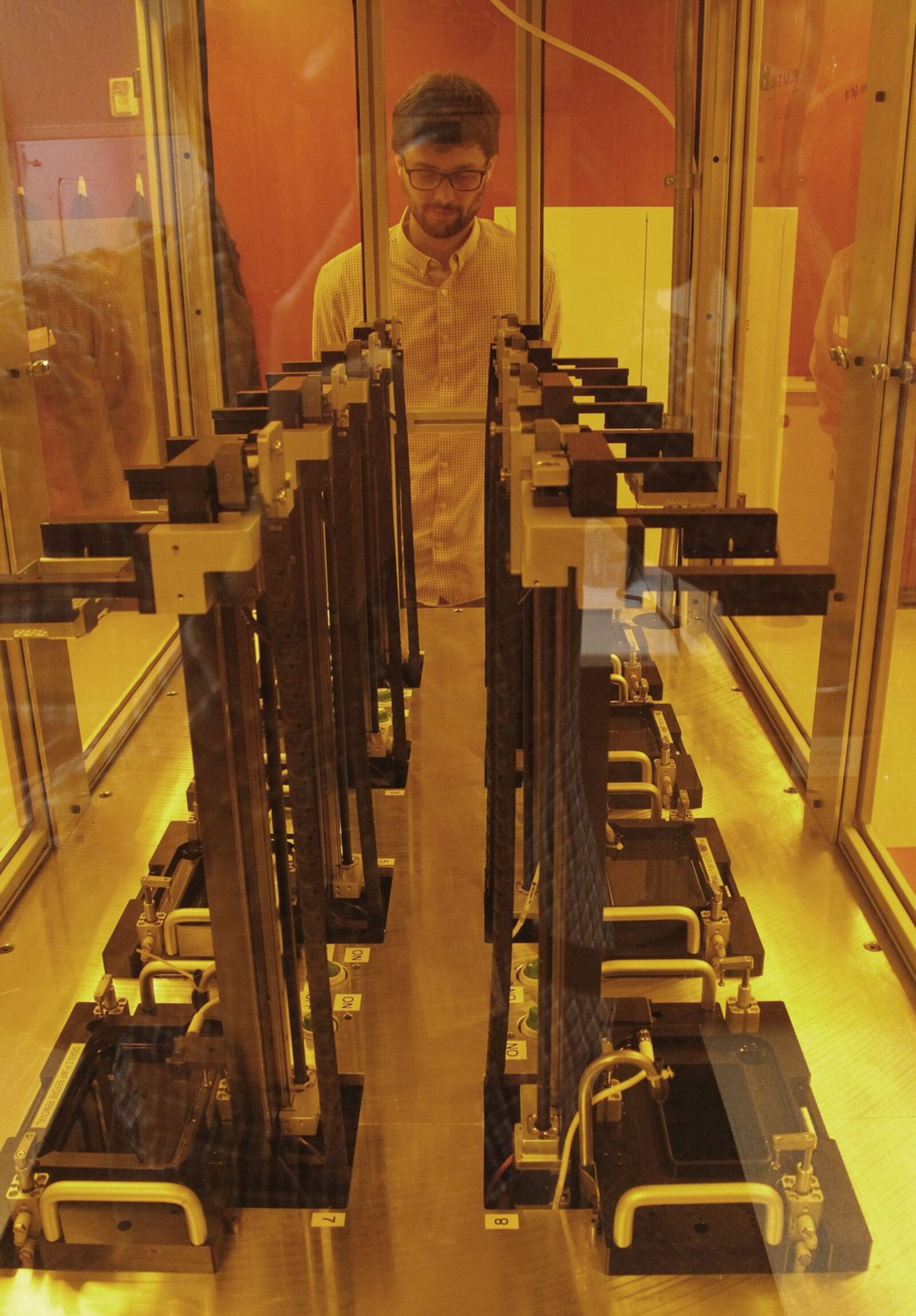 Tim Osborn, Group Leader for Additive Manufacturing Technology Development at the University of Dayton Research Institute, with a row of additive manufacturing machines, or 3-D printers, in the Additive Manufacturing Technology Development lab. TY GREENLEES / STAFF