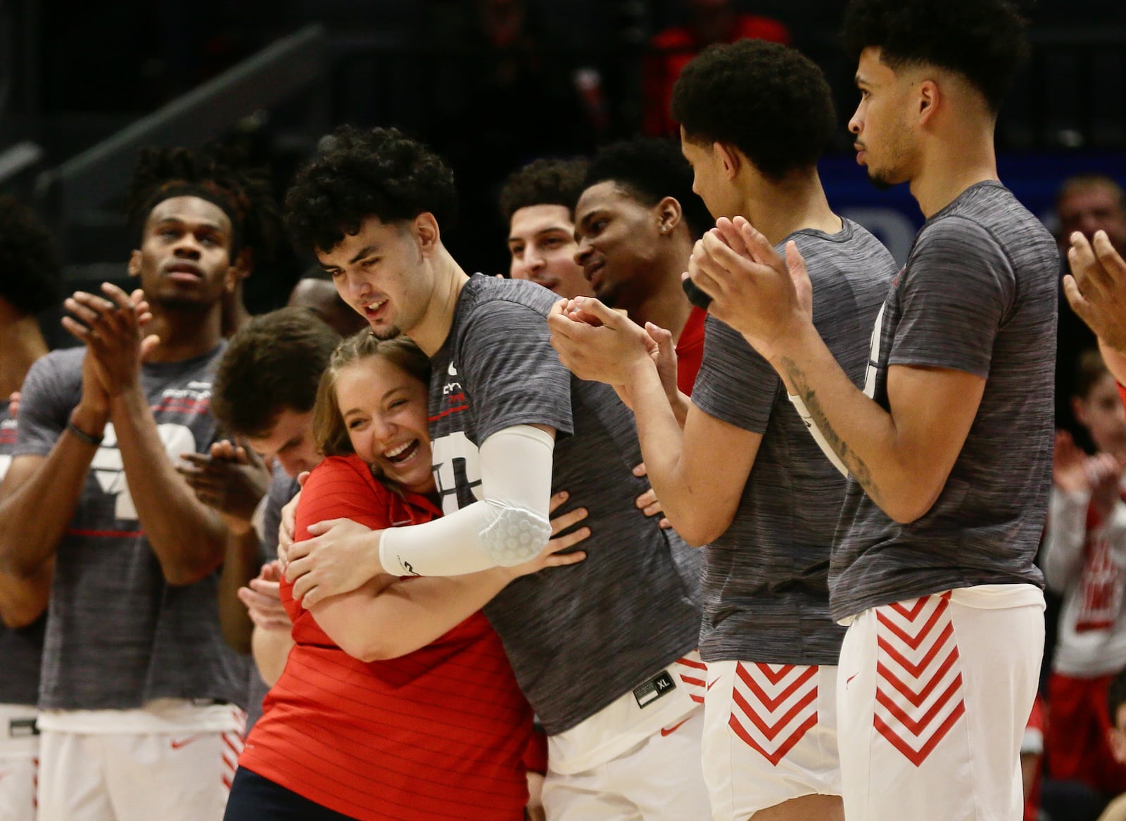 Dayton student manager Murphy Weiland hugs Mustapha Amzil as she is honored on Senior Day before a game against Davidson on Saturday, March 5, 2022, at UD Arena. David Jablonski/Staff