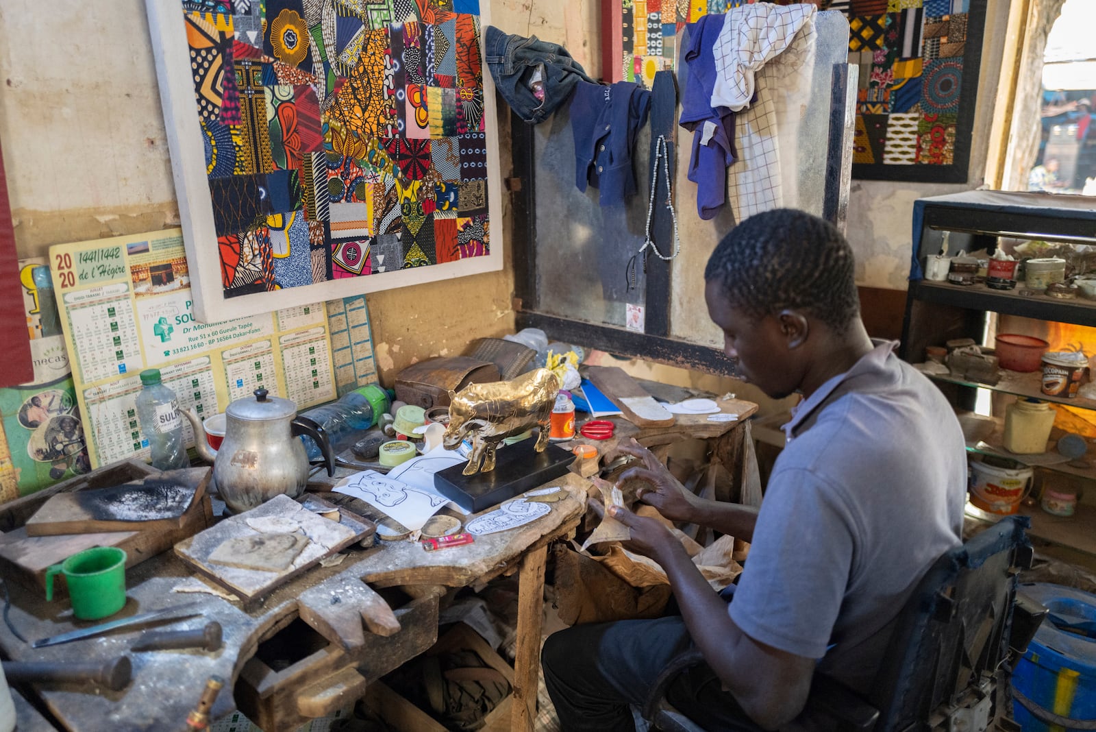 Jeweller Moussa Diop works on a bronze hippopotamus in his workshop, as part of the rebondir exhibition at the Dakar 2024 biennial Off in Dakar, Senegal, Thursday, Nov. 28, 2024. (AP Photo/Sylvain Cherkaoui)