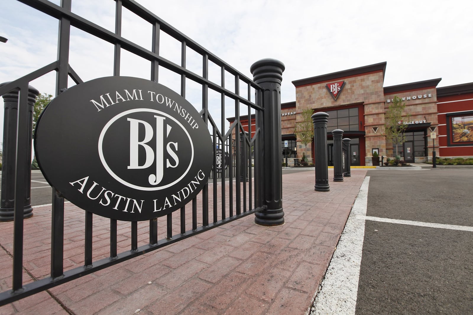 BJ’s Restaurant & Brewhouse, one of the more visible restaurants near the boulevard entrance, has black signs referencing both Austin Landing and Miami Twp. on black fencing in its parking lot. TY GREENLEES / STAFF