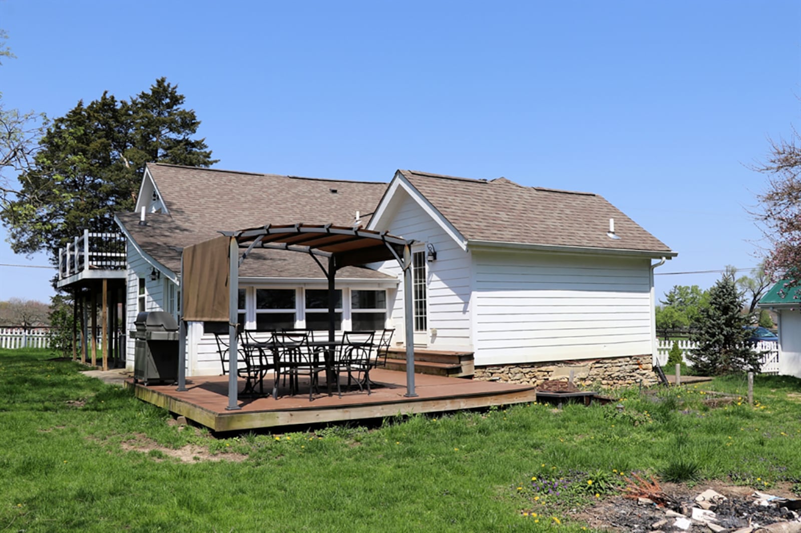 A covered porch wraps around nearly three sides of the house, and a composite deck includes a pergola. Outdoor furnishings and a gas grill are included. CONTRIBUTED PHOTO BY KATHY TYLER