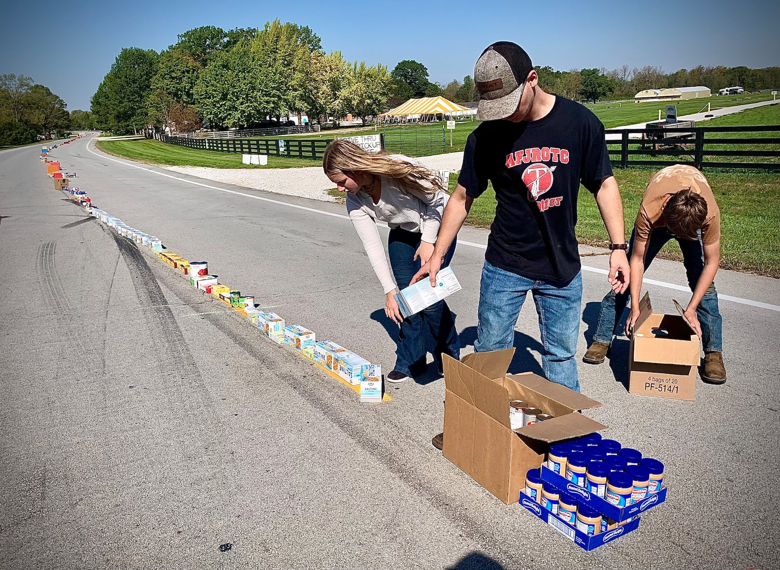 As part of the New Carlisle Heritage of Flight festival, residents, churches and businesses donated to the Mile of Food effort, stretching down Ohio 571 on Sunday morning, Oct. 6, 2024. The roughly 8,000 pounds of food collected reached 3/4 of a mile (the longest yet) and all will be given to the New Carlisle food bank. MARSHALL GORBY / STAFF