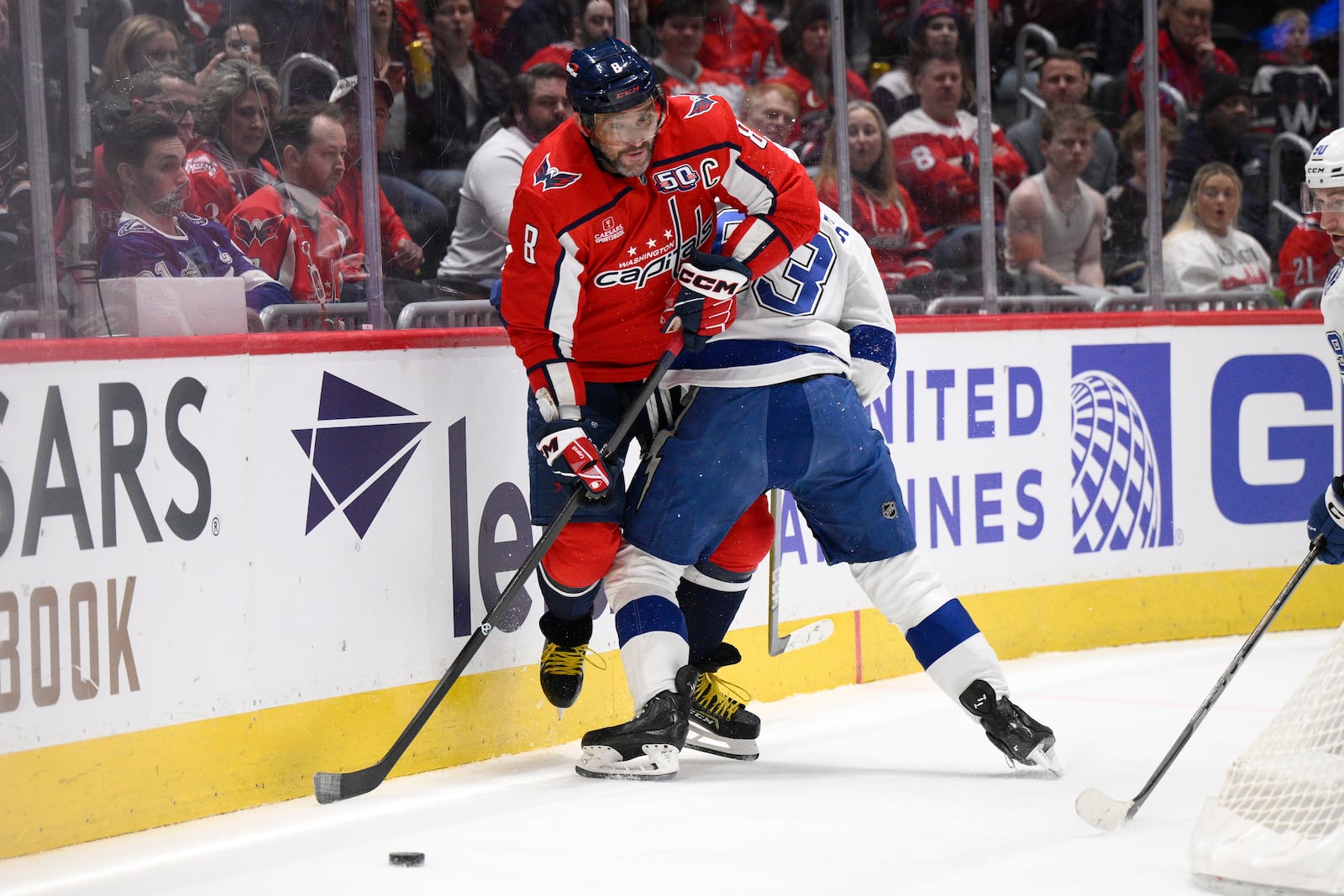 Washington Capitals left wing Alex Ovechkin (8) and Tampa Bay Lightning center Gage Goncalves, right, battle along the boards during the first period of an NHL hockey game, Saturday, March 1, 2025, in Washington. (AP Photo/Nick Wass)