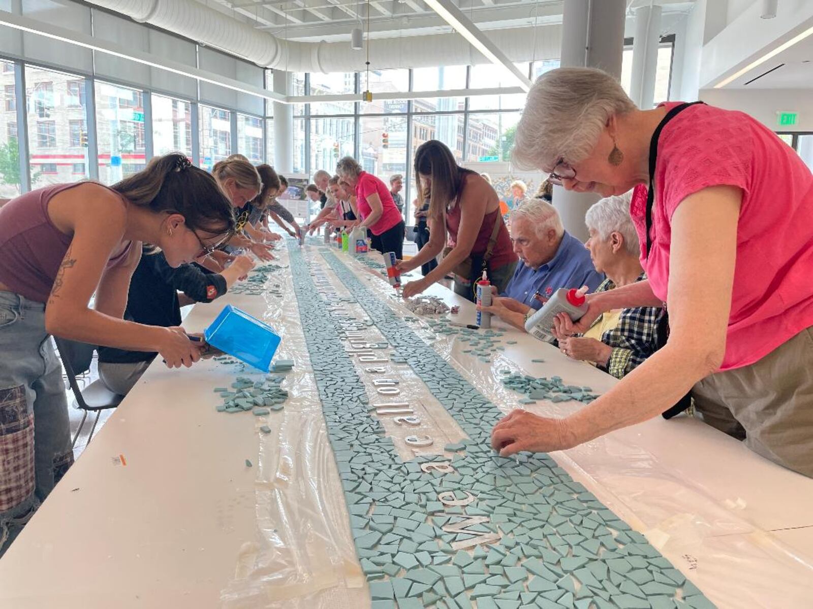 Community volunteers gathered July 11 at the Dayton Metro Library to finish the creation of the 8/4 Memorial mosaic. PHOTO BY RUSSELL FLORENCE JR.