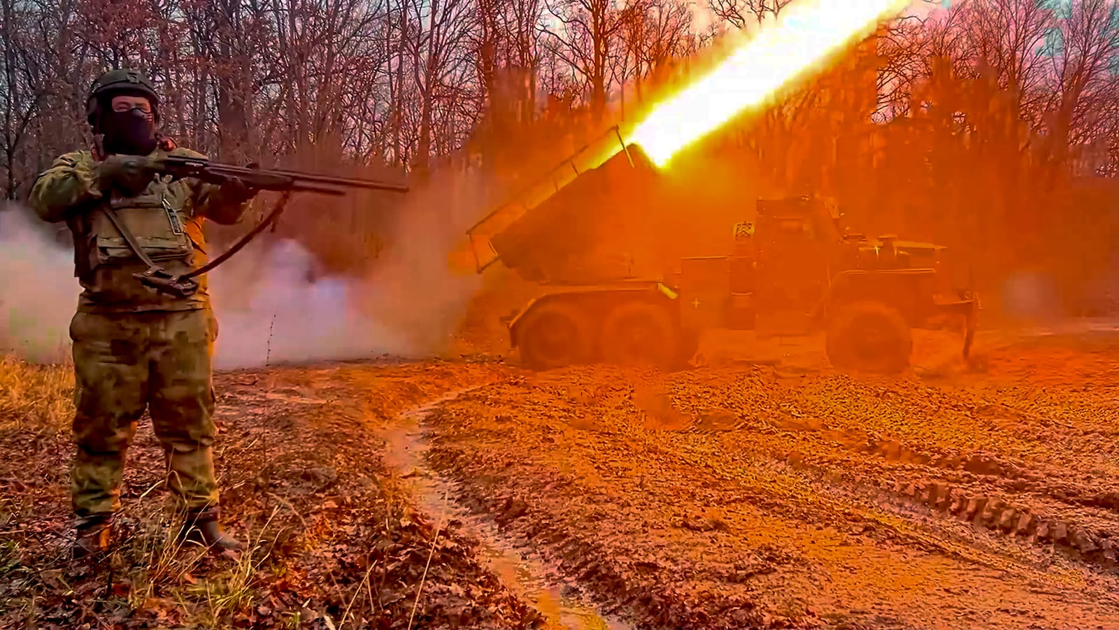 In this photo, taken from video and released by the Russian Defense Ministry Press Service on Thursday, Jan. 16, 2025, a Russian "Grad" self-propelled multiple rocket launcher fires towards Ukrainian positions as a soldier gets ready to shoot drones in Ukraine. (Russian Defense Ministry Press Service via AP)