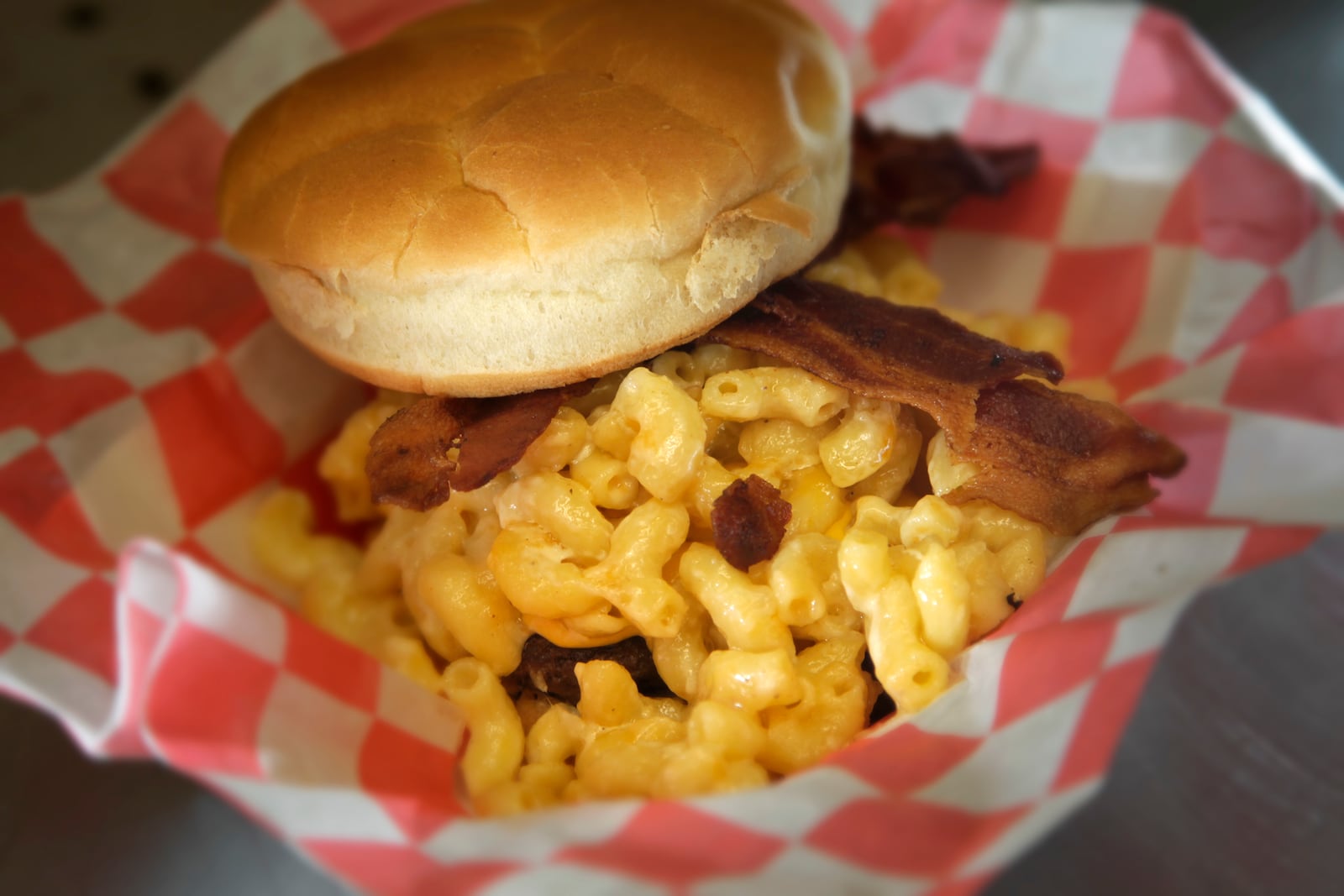 McNasty's OMG Burger is made with bacon and American cheese and smothered in macaroni and cheese. LISA POWELL / STAFF