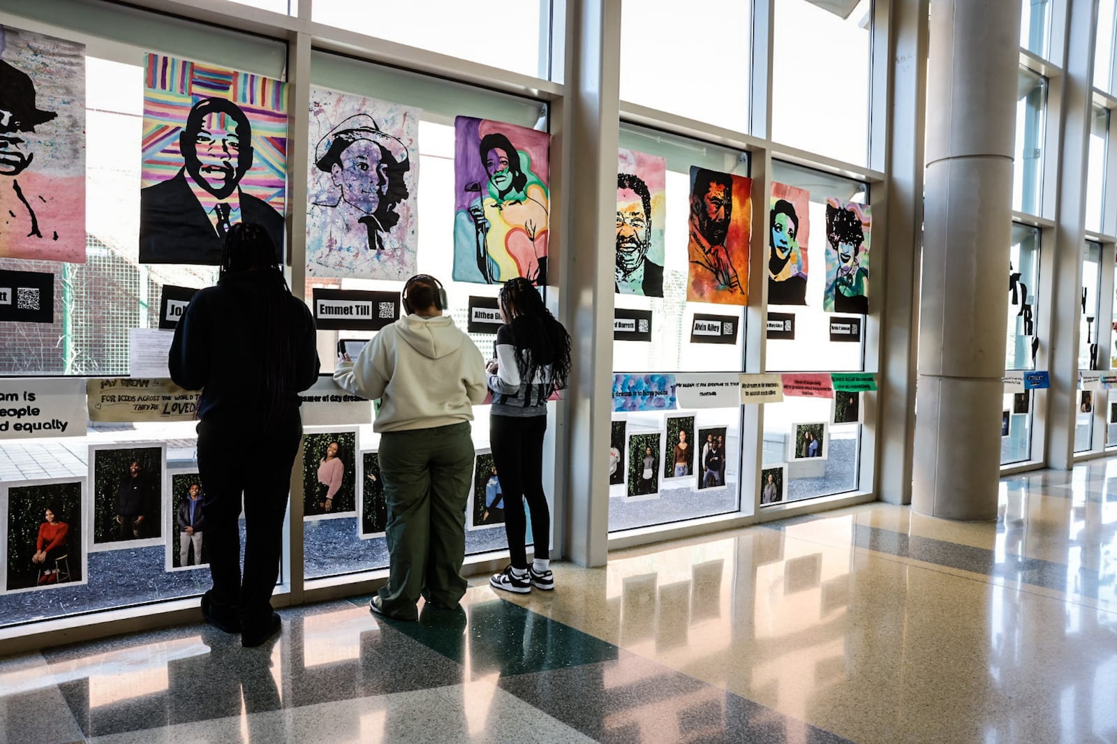 Northmont High School students study artwork of famous Black Americans that hangs in the foyer of the school. The Black student association put together an art exhibit showcasing Black history, which was put on display this month. JIM NOELKER/STAFF