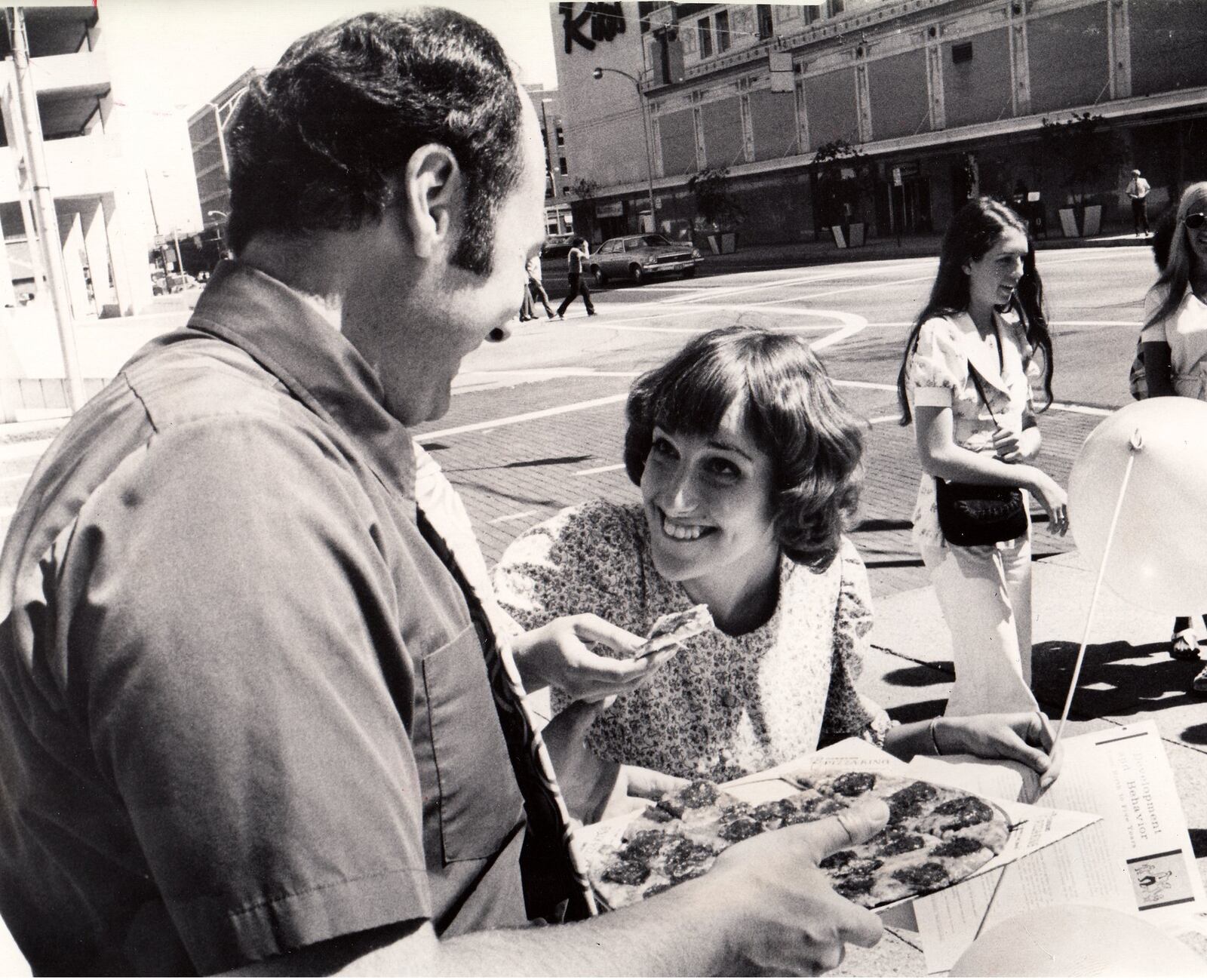 Vic Cassano Jr. hands out free pizza to Nannet Selleards while marking the 20 year anniversary of Cassano Pizza Kings in 1973.