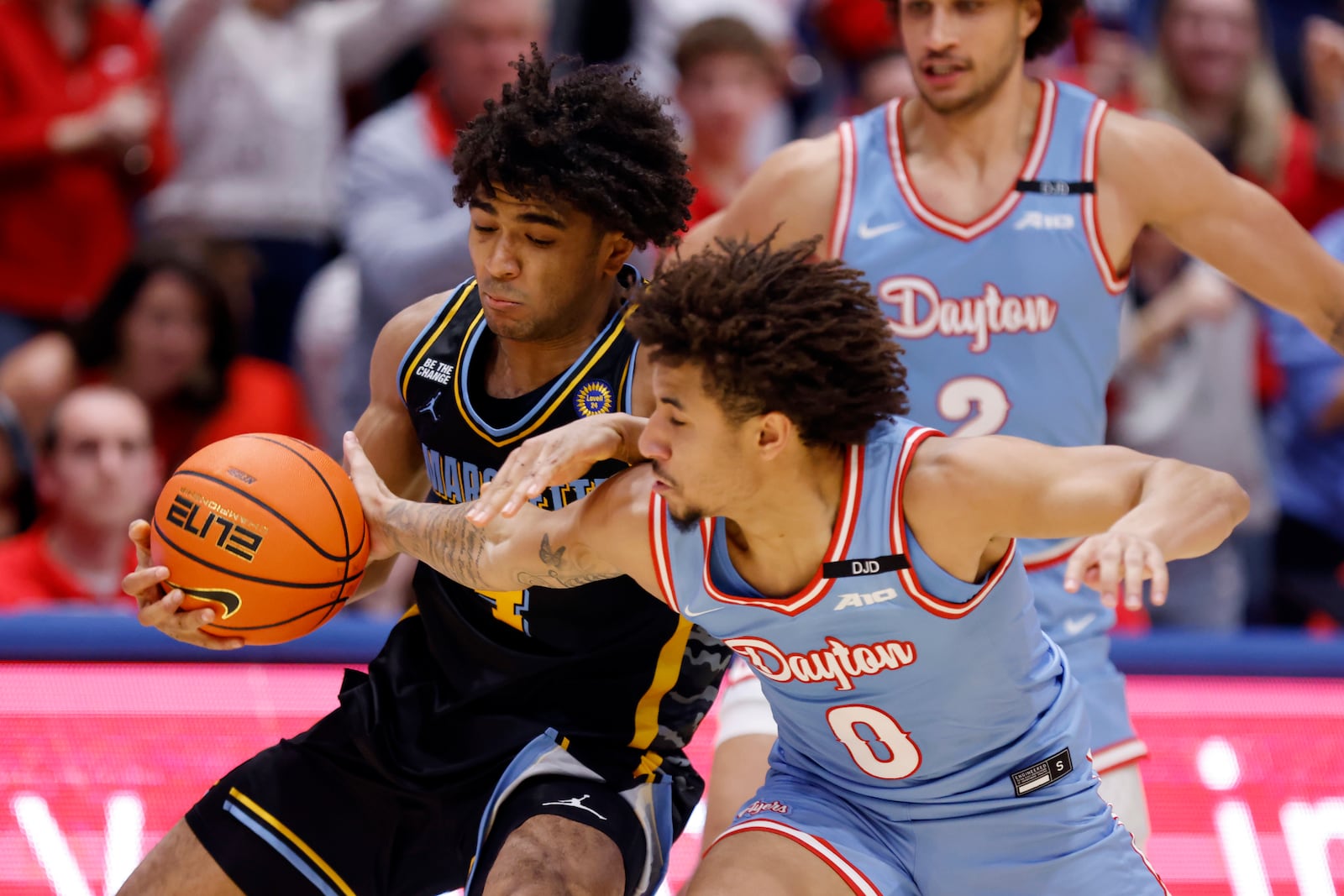 Dayton guard Javon Bennett (0) reaches for the ball against Marquette guard Stevie Mitchell, left, during the second half of an NCAA college basketball game in Dayton, Ohio, Saturday, Dec. 14, 2024. (AP Photo/Paul Vernon)