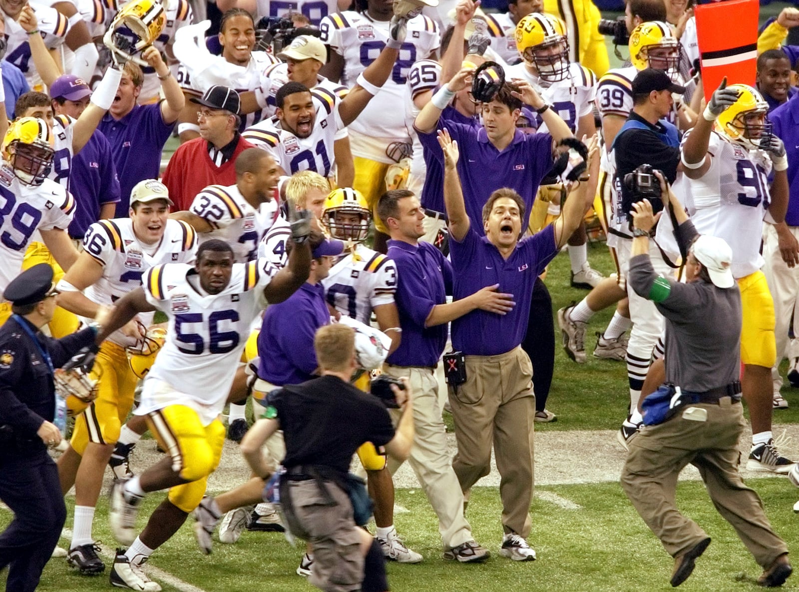 FILE - Louisiana State University coach Nick Saban, second from right foreground, raises his arms as he is celebrates LSU's 21-14 victory over Oklahoma in the Sugar Bowl at the Louisiana Superdome in New Orleans, Jan, 4, 2004. (AP Photo/Andrew Cohoon, File)