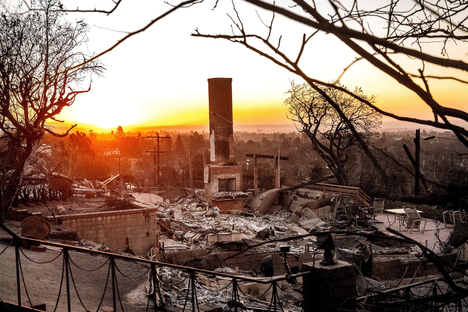 The sun rises behind a home destroyed by the Palisades Fire in the Pacific Palisades community of Los Angeles on Sunday, Jan. 12, 2025, (AP Photo/Noah Berger)