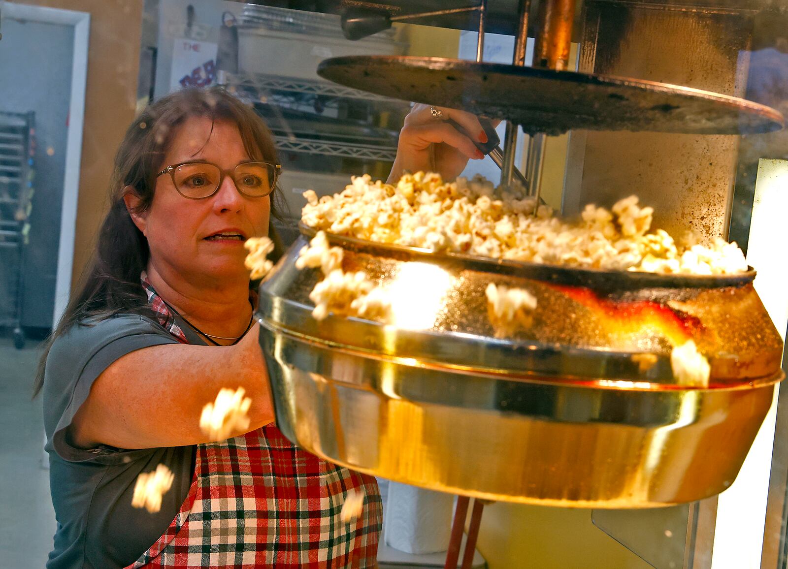 Kathy Brougher, an employee of The Peanut Shoppe, makes fresh popcorn for a customer Tuesday, Nov. 21, 2023. BILL LACKEY/STAFF