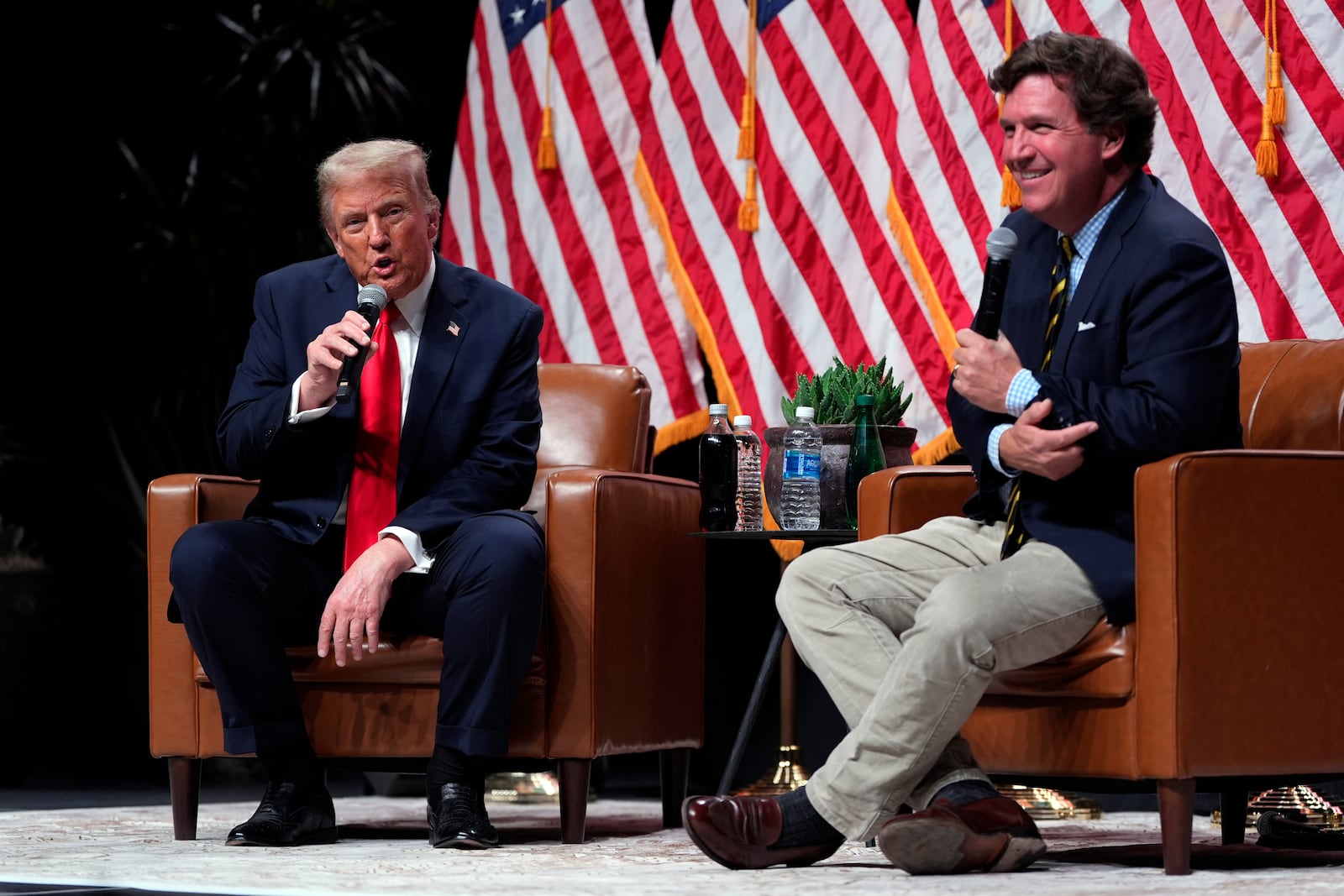 Republican presidential nominee former President Donald Trump speaks with Tucker Carlson during a Tucker Carlson Live Tour show at Desert Diamond Arena, Thursday, Oct. 31, 2024, in Glendale, Ariz. (AP Photo/Julia Demaree Nikhinson)