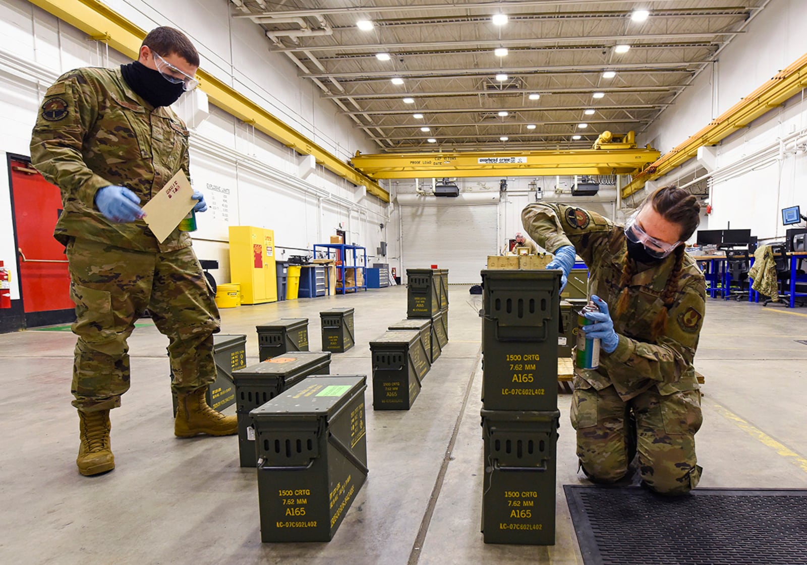 Senior Airman Ryan Klingbeil, an 88th Operations Support Squadron storage crew chief, and Staff Sgt. Jacklyn Hill, an 88 OSS munitions inspector, stencil ammo boxes for packing March 3 at Wright-Patterson Air Force Base. The Munitions Flight ships, stores, inspects, receipts and accounts for all ammo assets on Wright-Patt. U.S. AIR FORCE PHOTO/TY GREENLEES