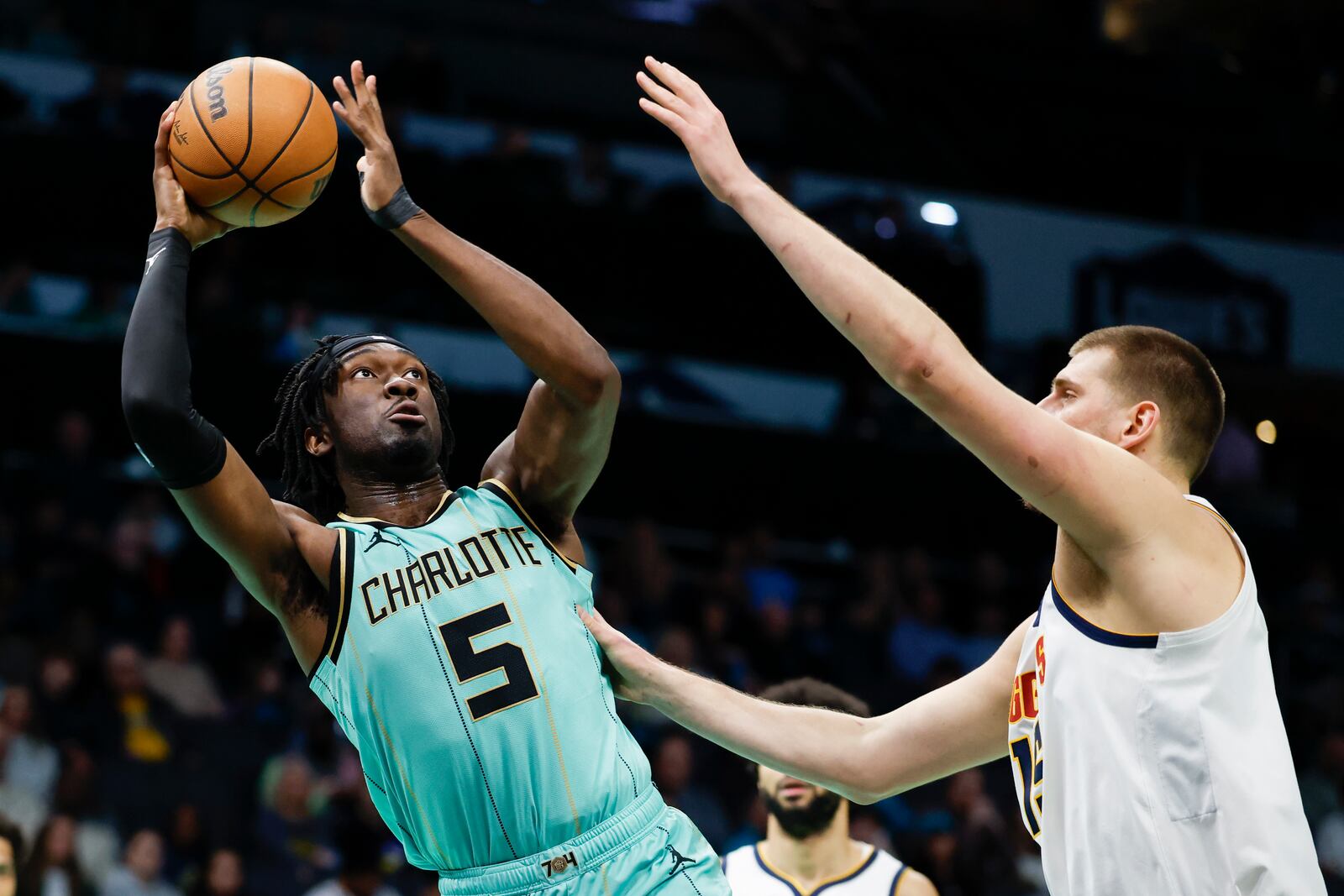 Charlotte Hornets center Mark Williams (5) looks to shoot against Denver Nuggets center Nikola Jokic, right, during the first half of an NBA basketball game in Charlotte, N.C., Saturday, Feb. 1, 2025. (AP Photo/Nell Redmond)