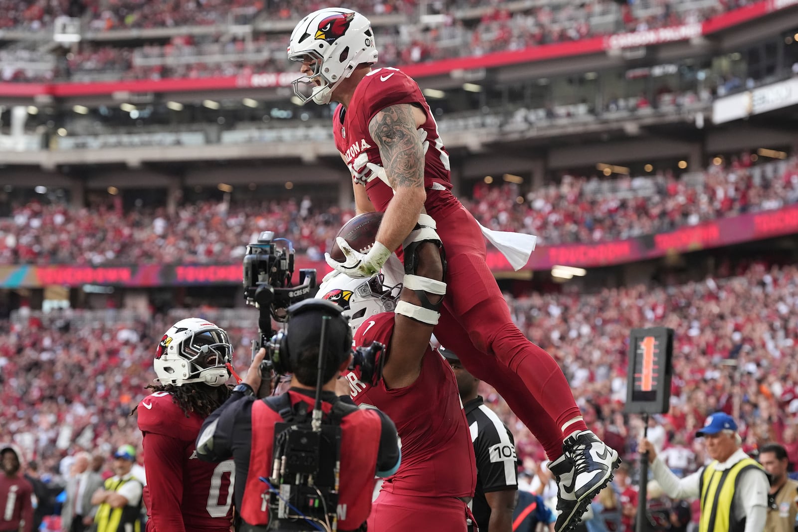 Arizona Cardinals tight end Trey McBride is hoisted by teammates after his touchdown against the Chicago Bears during the first half of an NFL football game, Sunday, Nov. 3, 2024, in Glendale, Ariz. (AP Photo/Ross D. Franklin)