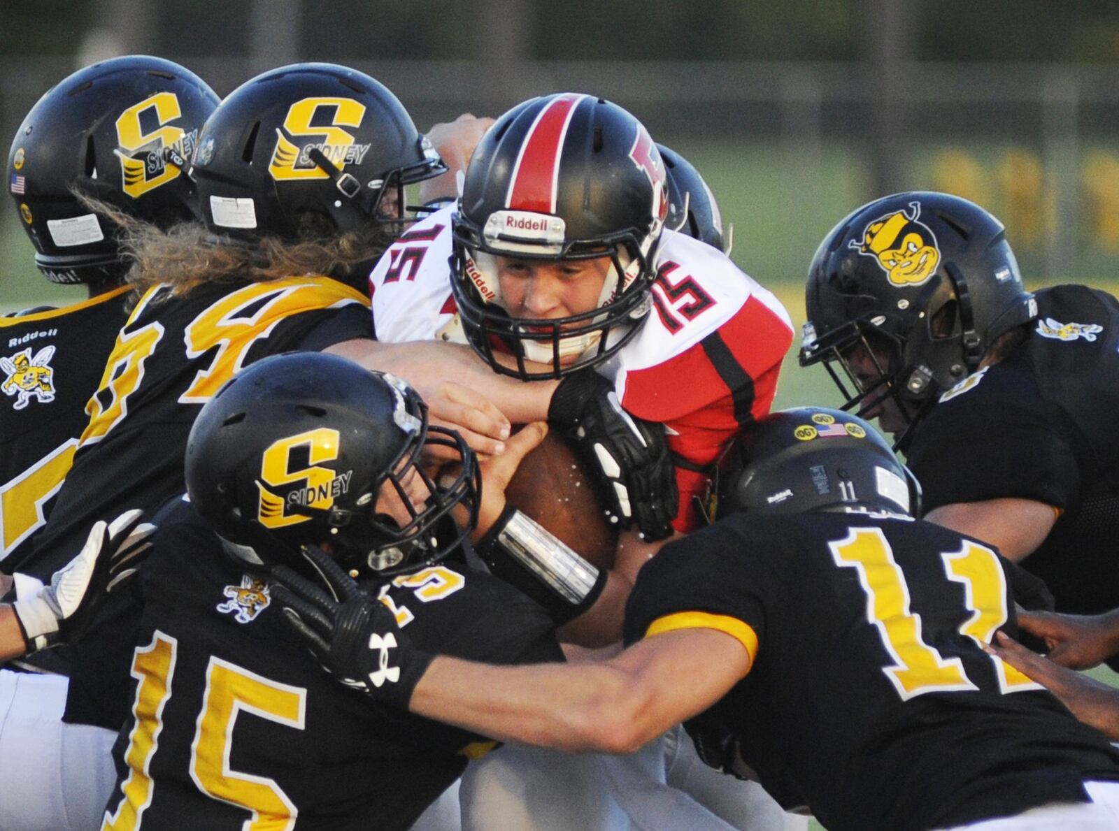 Bellefontaine junior quarterback Grant Smith draws Sidney defenders Joey Biship (64), Ryan Cagle (15) and Caleb Harris (11). Sidney defeated visiting Bellefontaine 31-28 in a Week 2 high school football game on Thursday, Aug. 30, 2018. MARC PENDLETON / STAFF